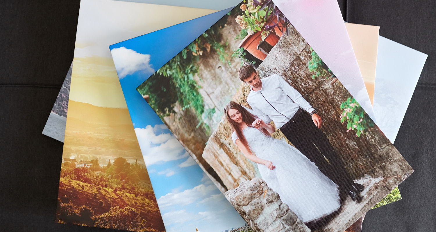 Printed wedding photo of a couple atop a stack of photographs