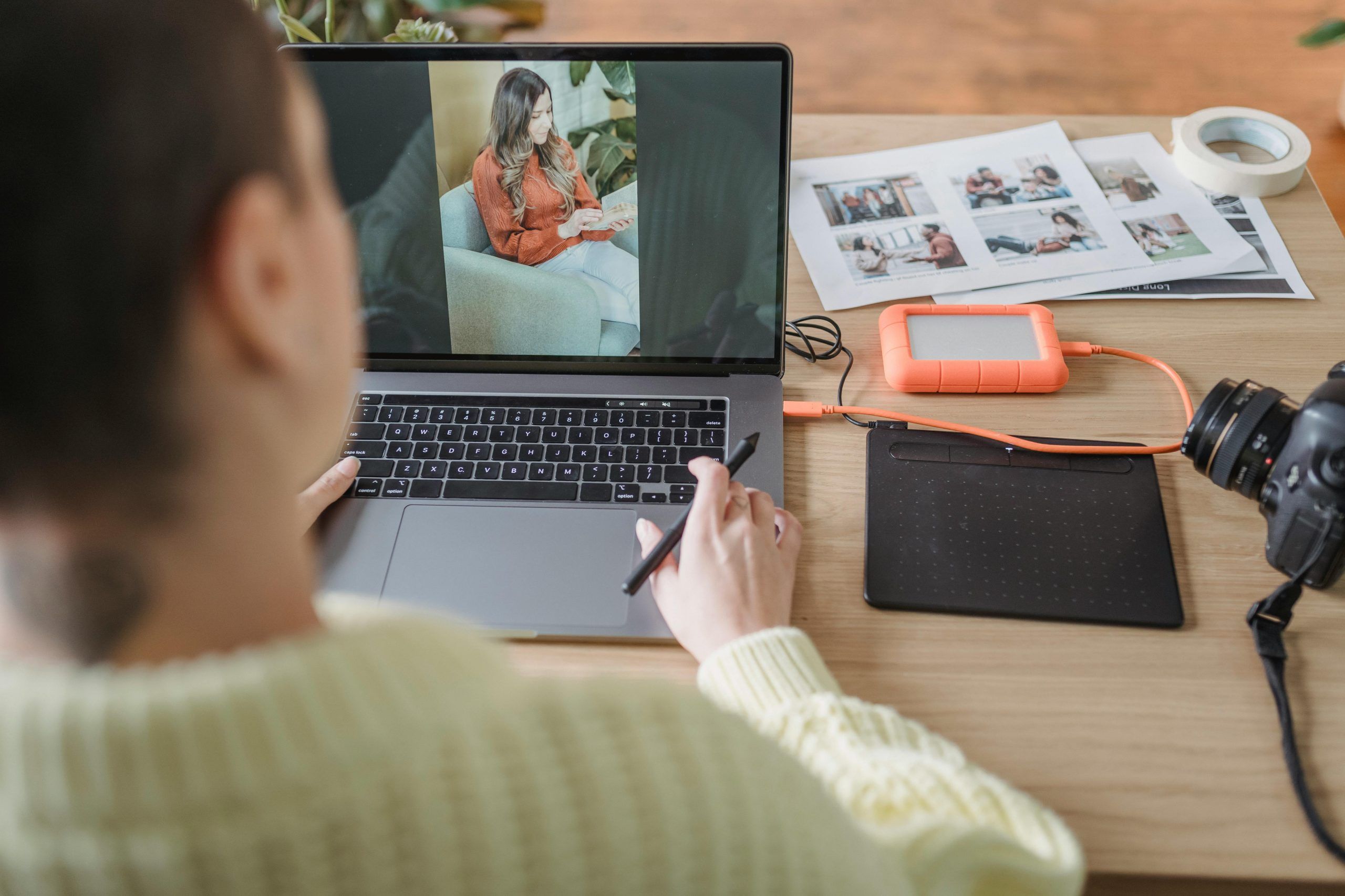 Photographer edits a portrait on a laptop beside camera equipment