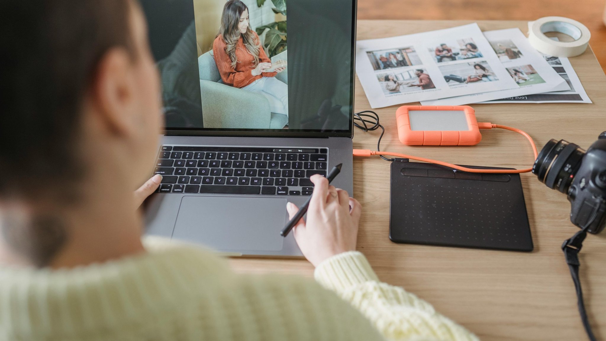 Photographer edits a portrait on a laptop beside camera equipment