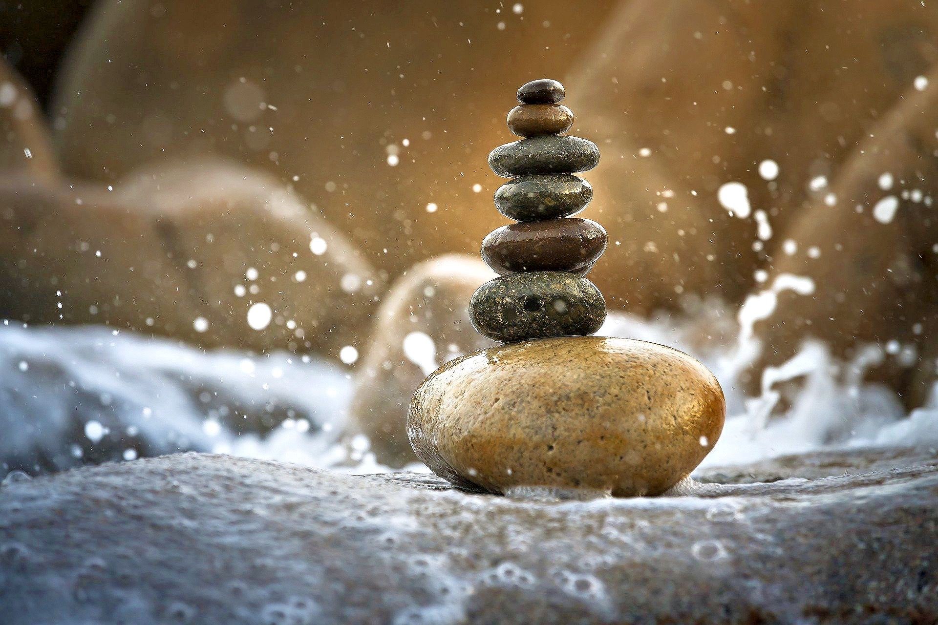 Stack of balanced stones surrounded by splashing water