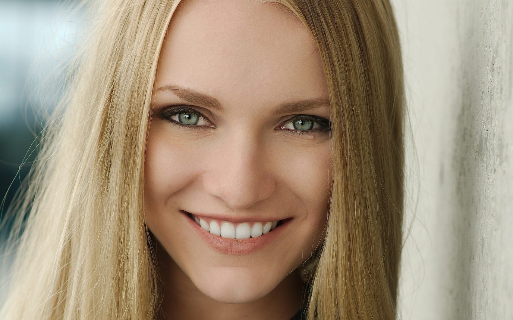 Woman with long blonde hair smiling at the camera
