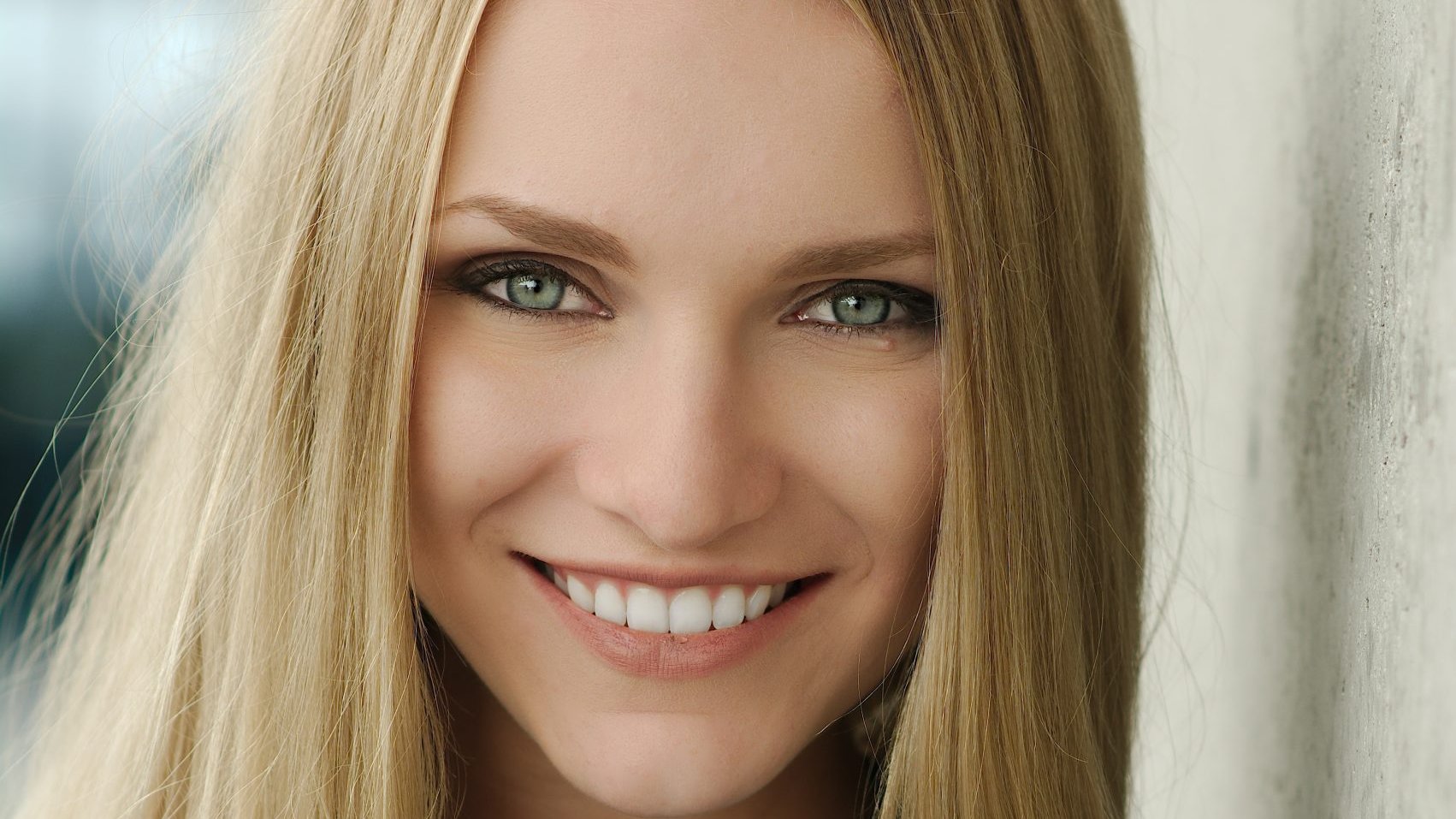Woman with long blonde hair smiling at the camera
