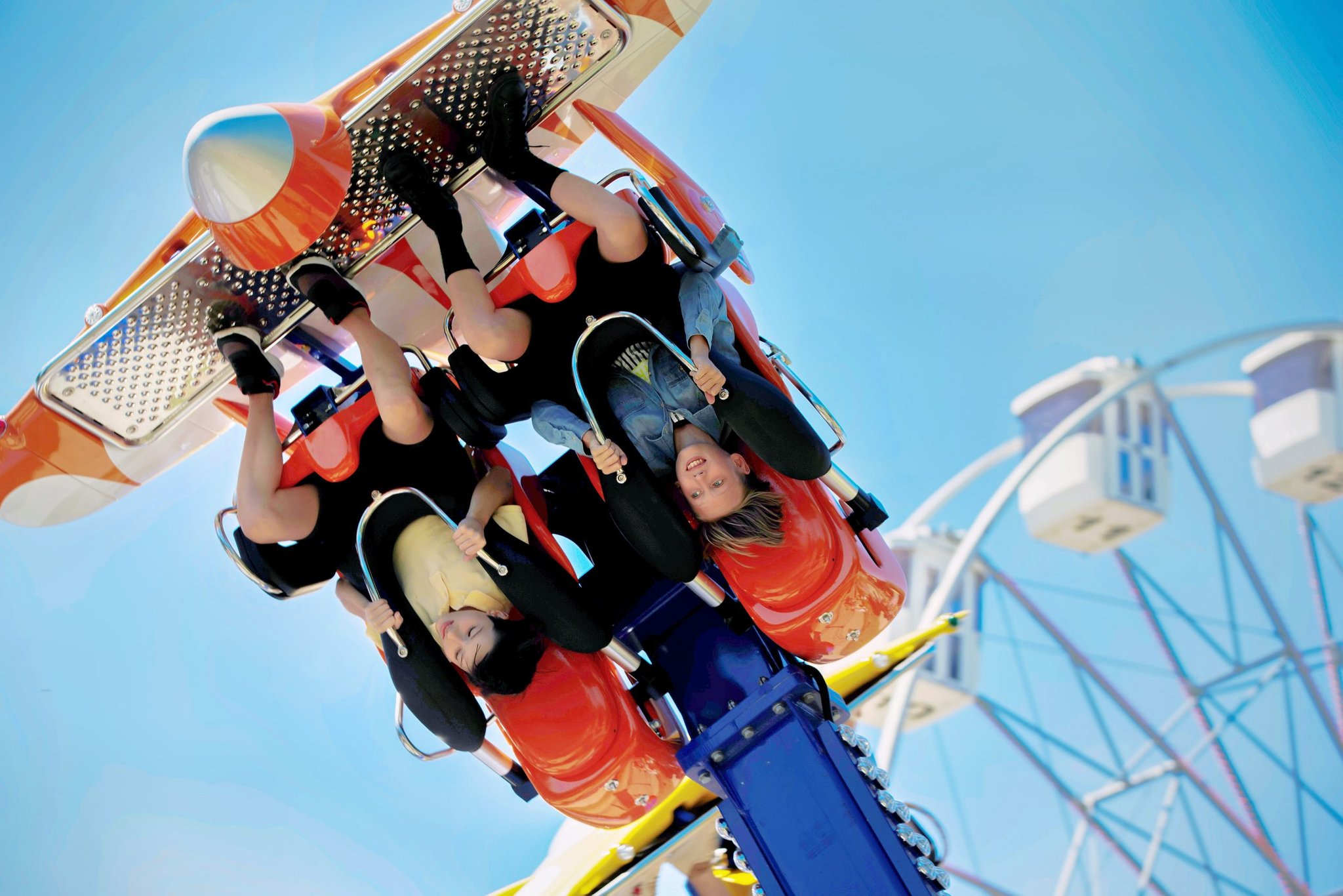 Two riders hang upside down on an amusement park ride