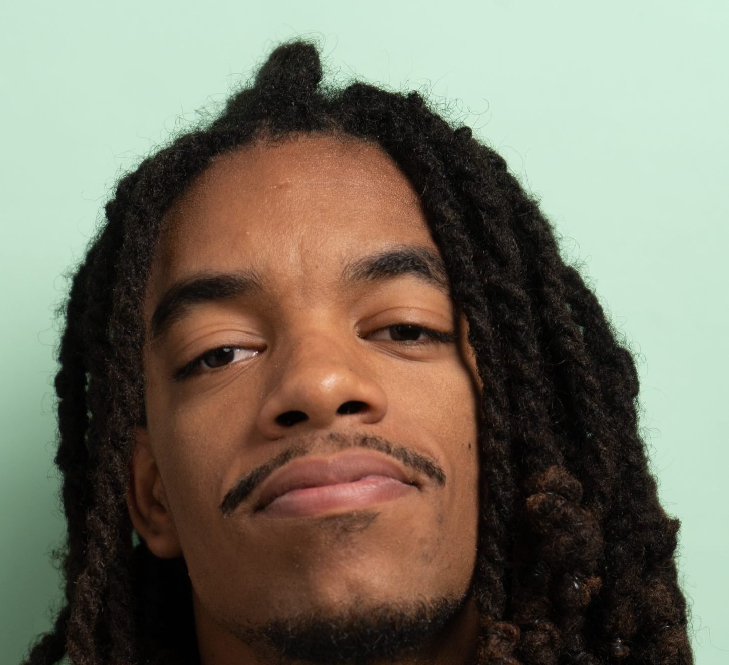 Man with long dreadlocks looking at the camera