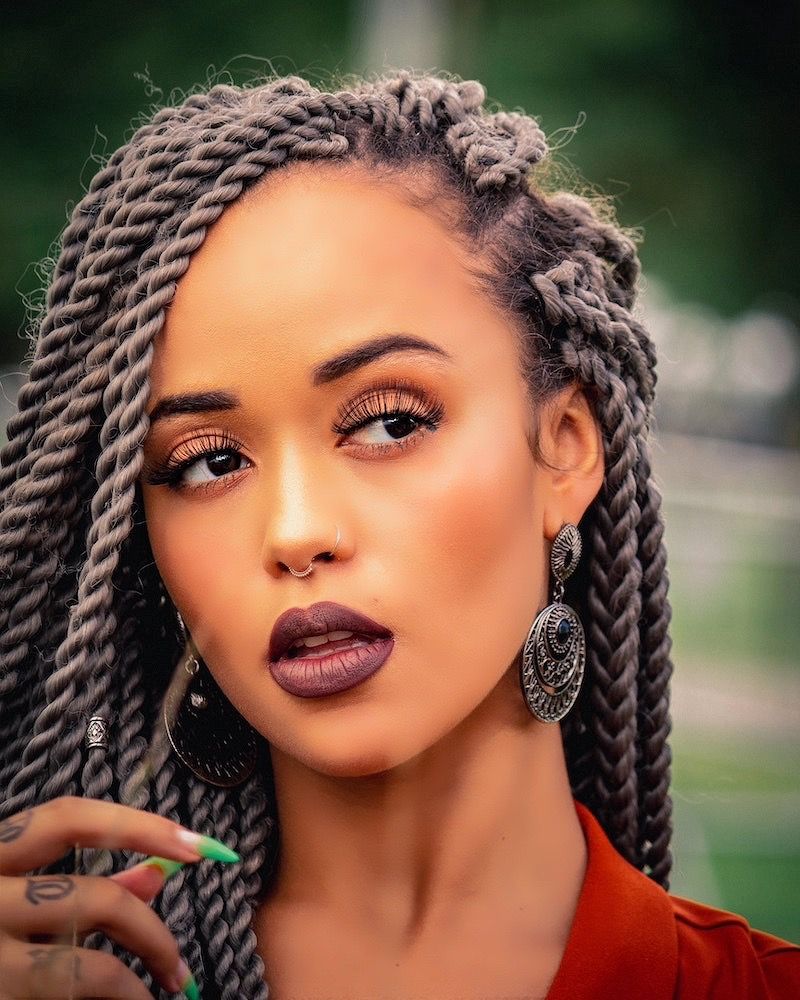 Woman with long twists, nose rings and ornate earrings