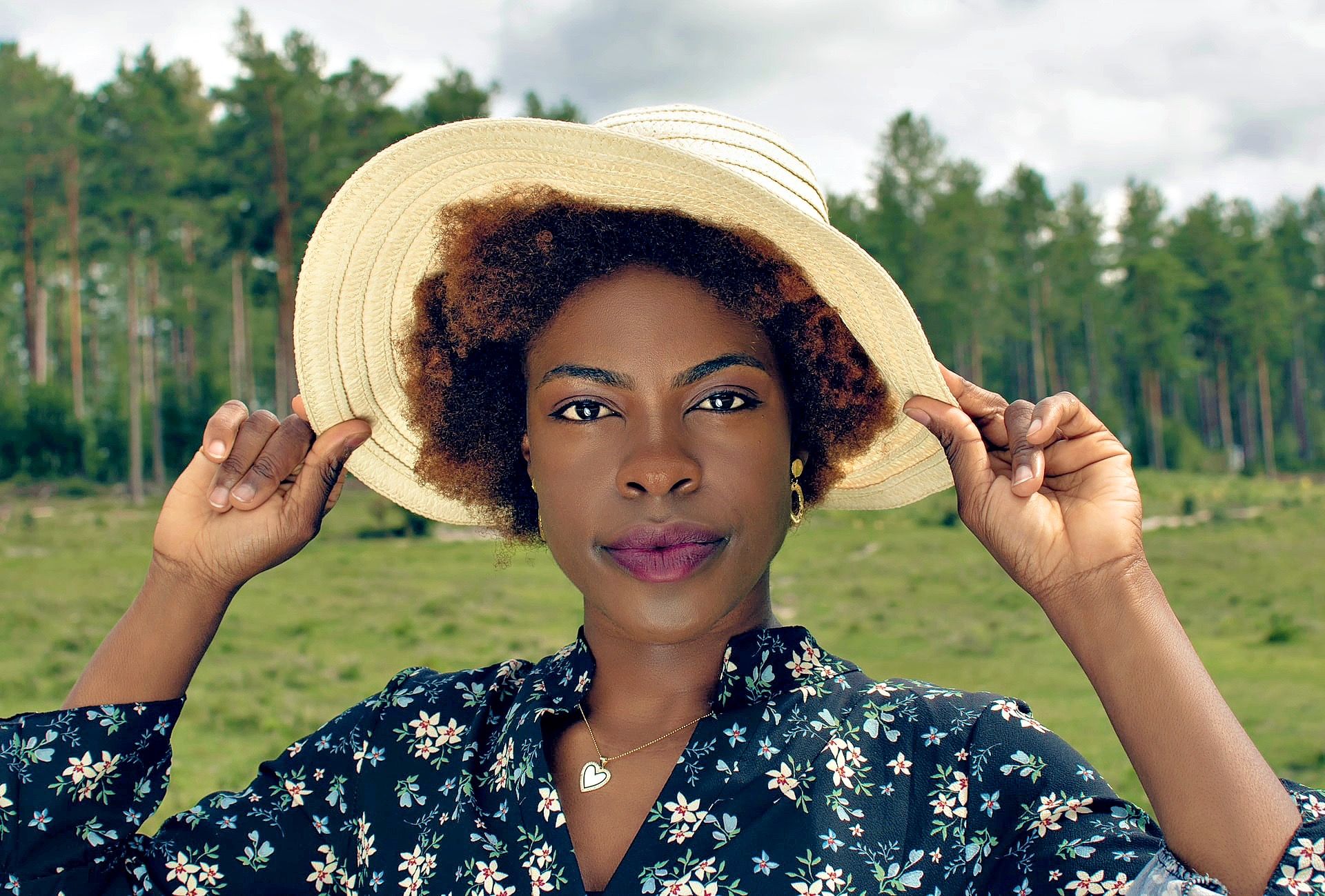 Woman holding the brim of her sun hat outdoors