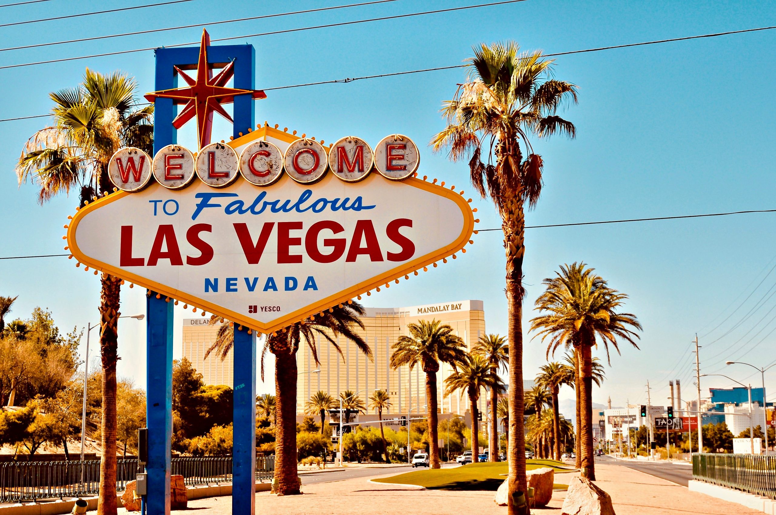 “Welcome to Fabulous Las Vegas Nevada” sign beside palm-lined boulevard