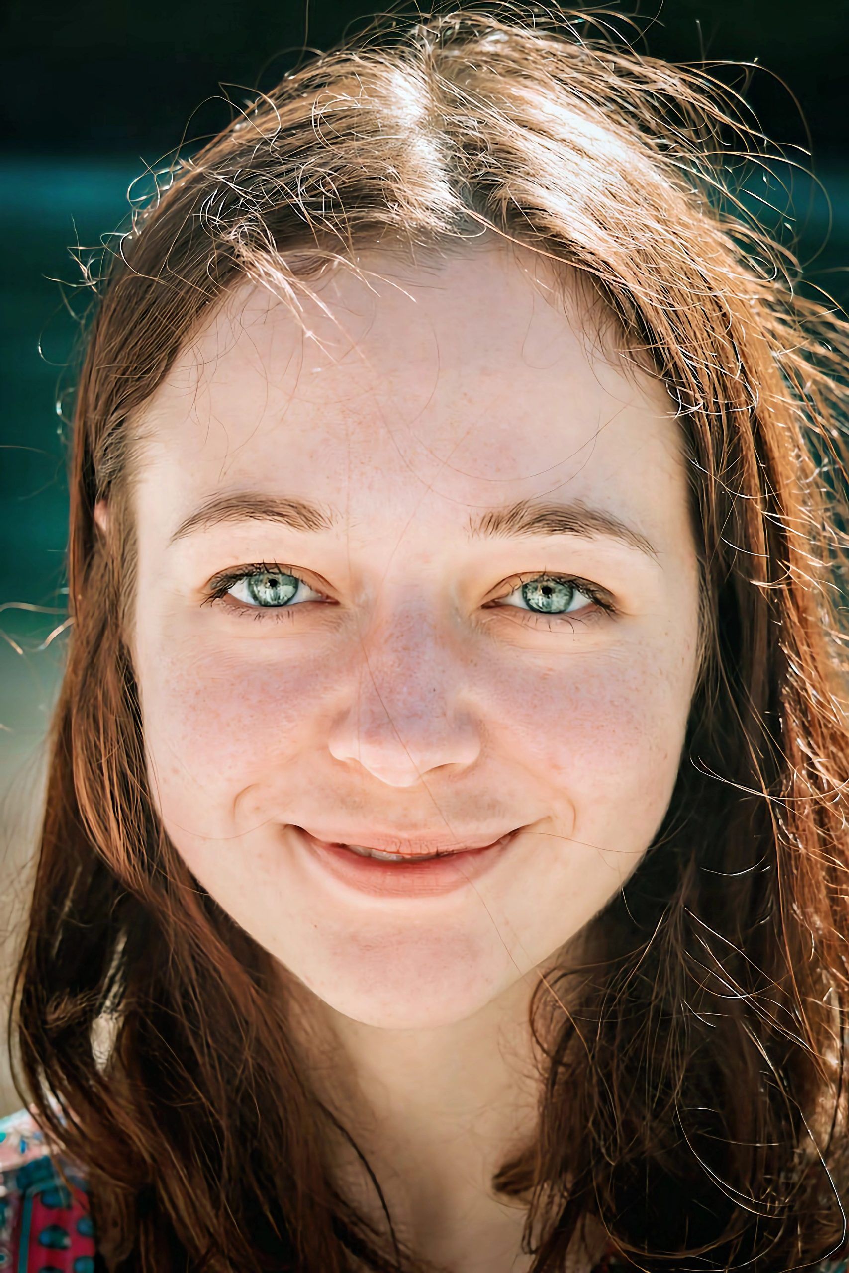 Young woman with brown hair smiling at the camera
