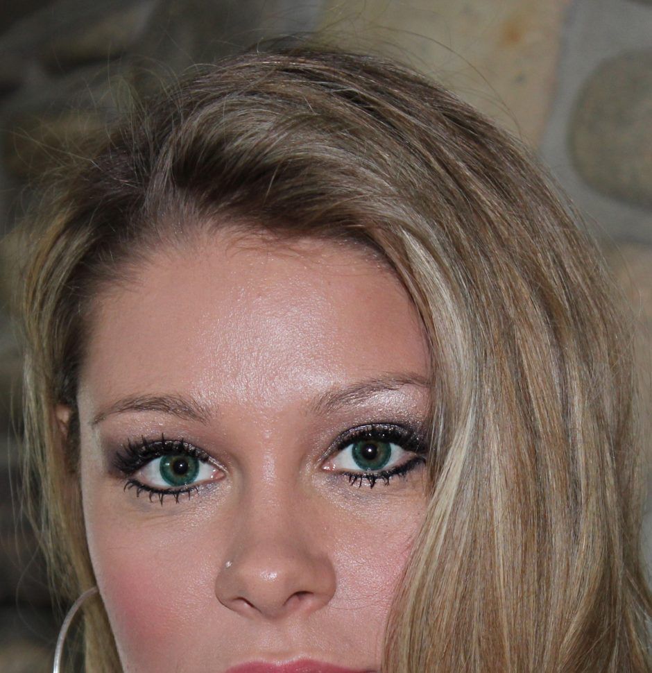 Woman with blonde hair and green eyes looking at the camera
