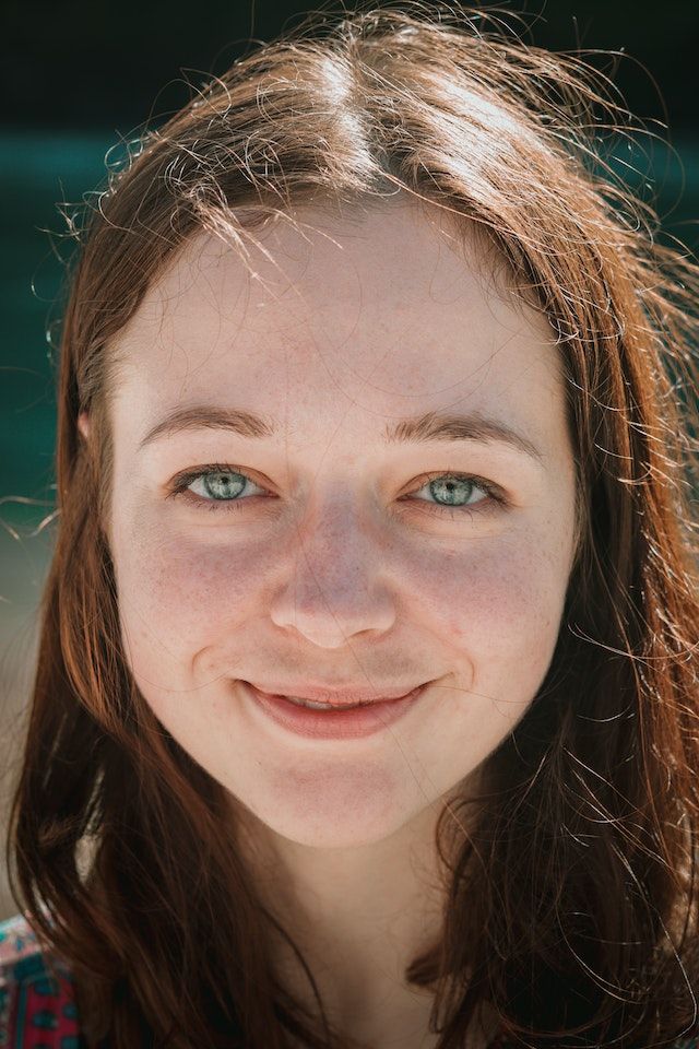 Young woman with long brown hair smiling at the camera