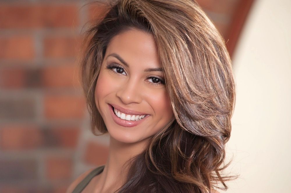 Woman with long brown hair smiling at the camera