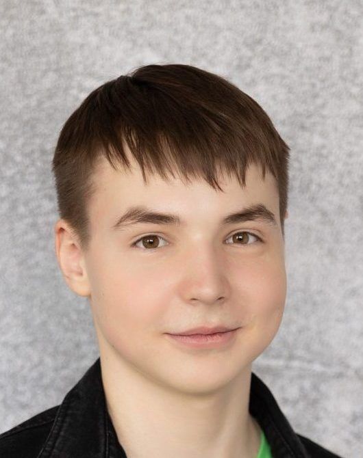 Young person with short brown hair facing the camera