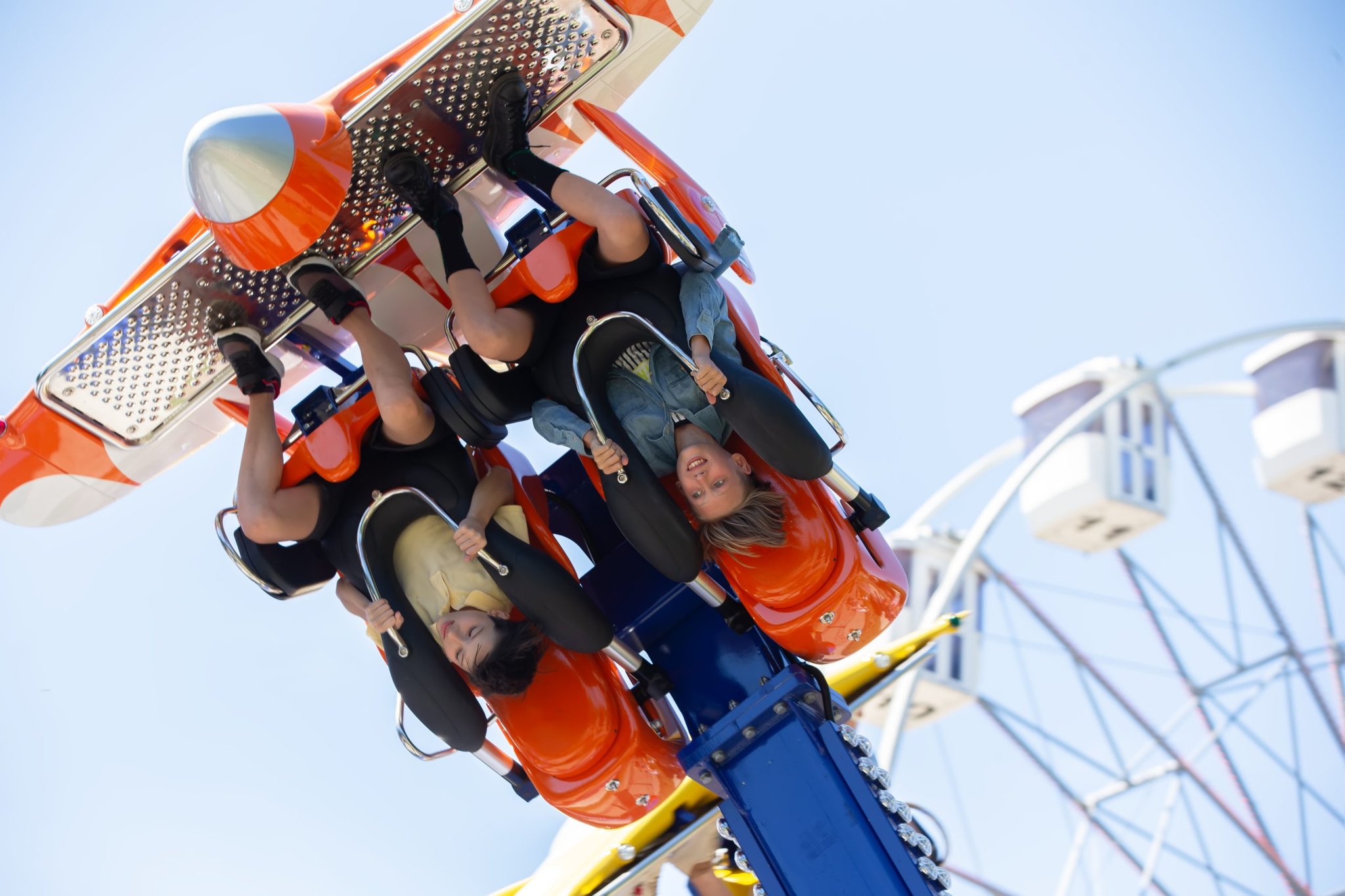 Two riders hang upside down on an amusement park ride