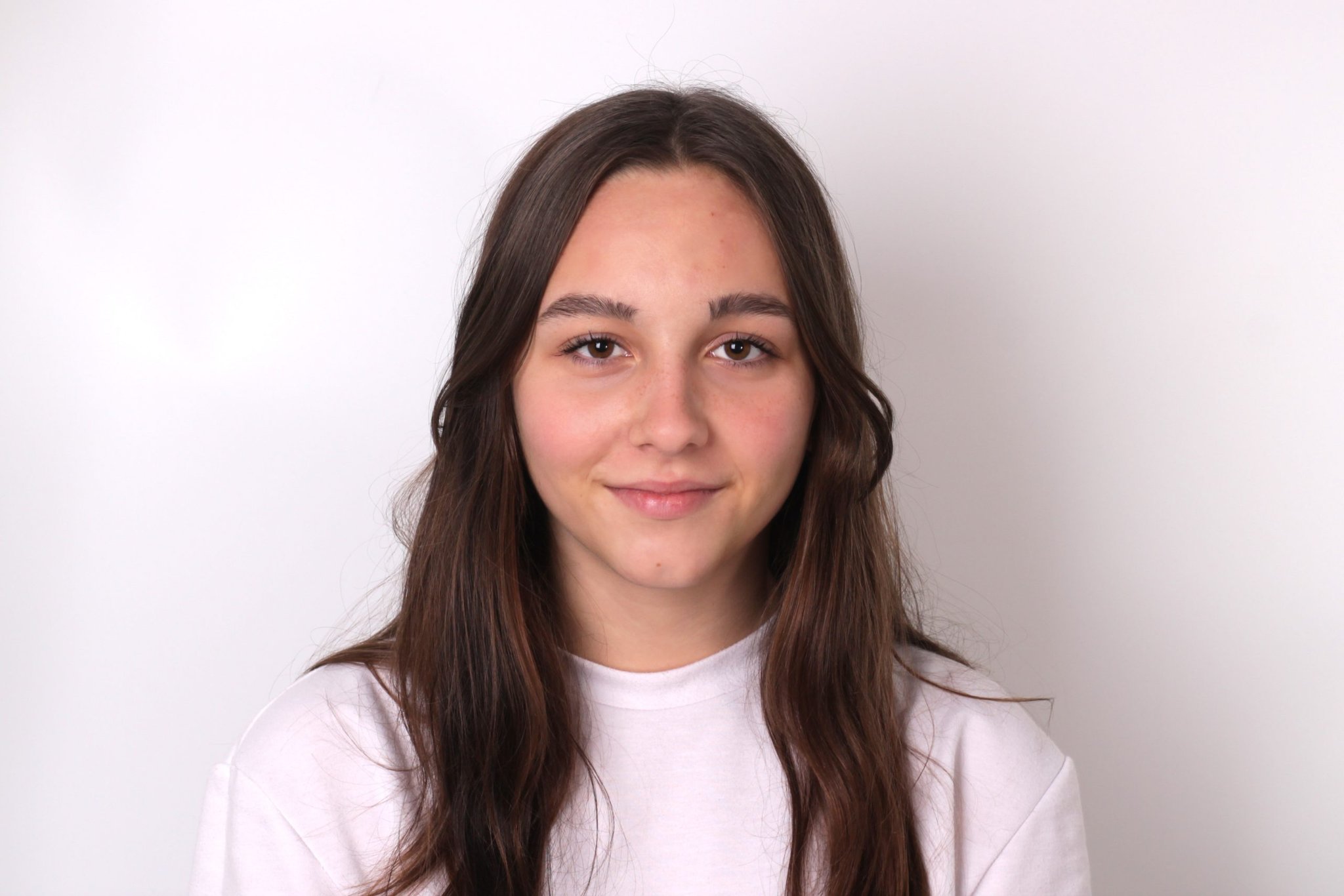 Young woman with long brown hair looking at the camera