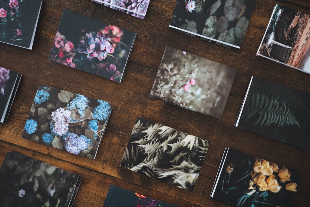 Floral and nature photographs arranged across a wooden table