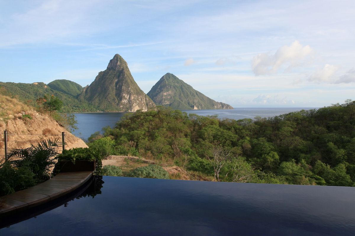 Infinity pool overlooking forested mountains and the sea