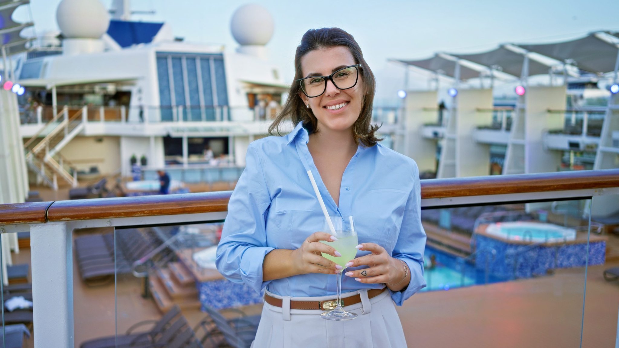 Woman holding a drink on a cruise ship deck
