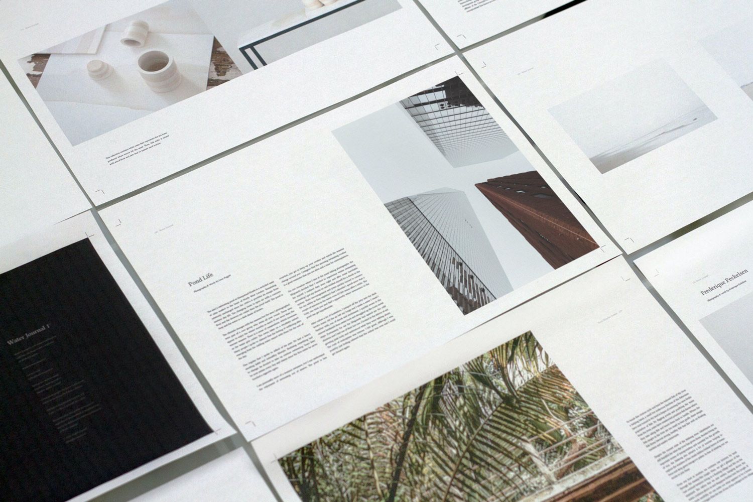 Printed page layouts with photographs and text spread across a table