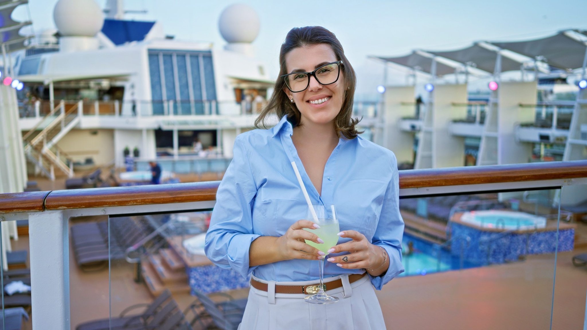 Woman holding a drink on a cruise ship deck