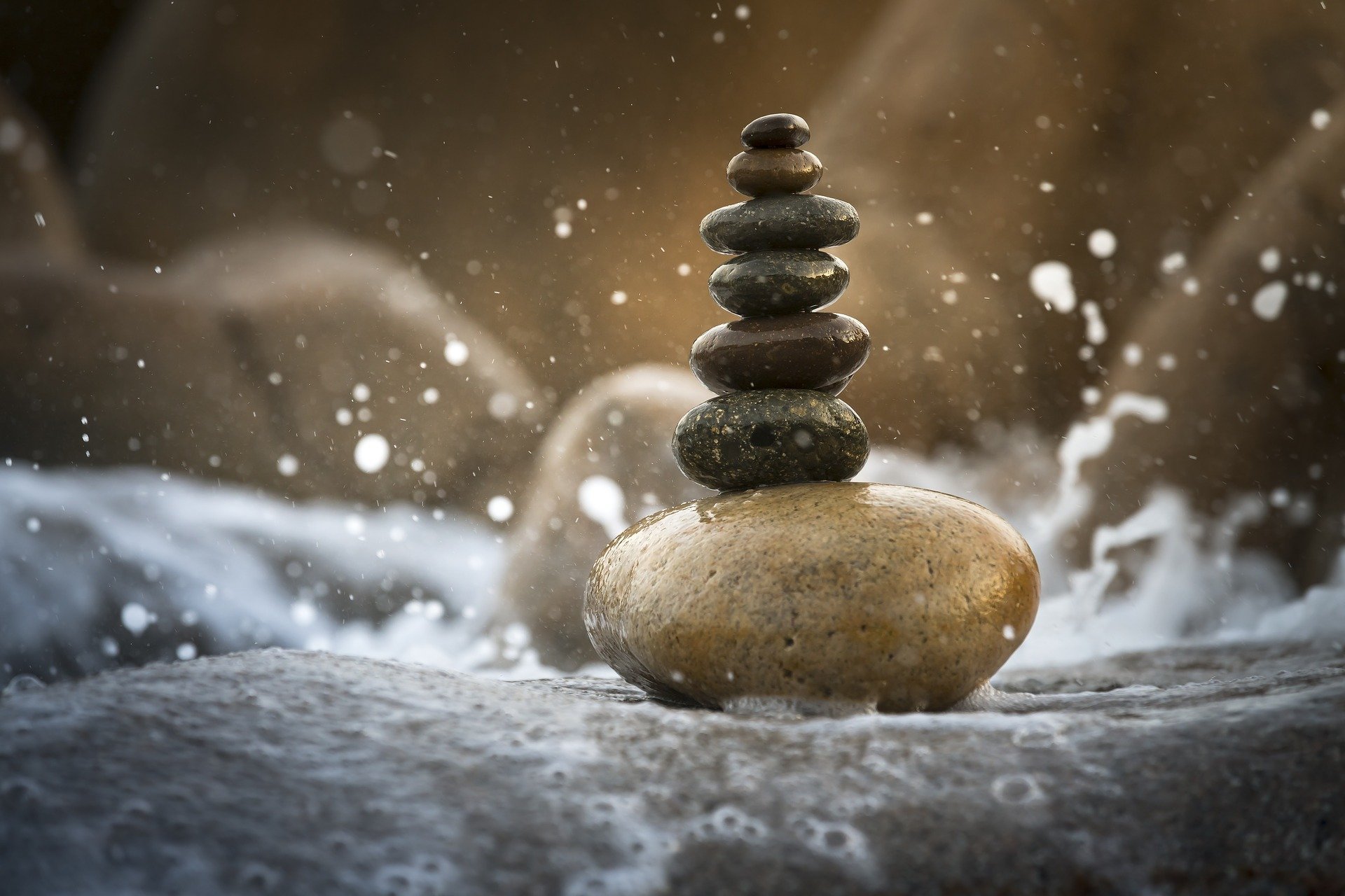 Stack of balanced stones amid splashing water