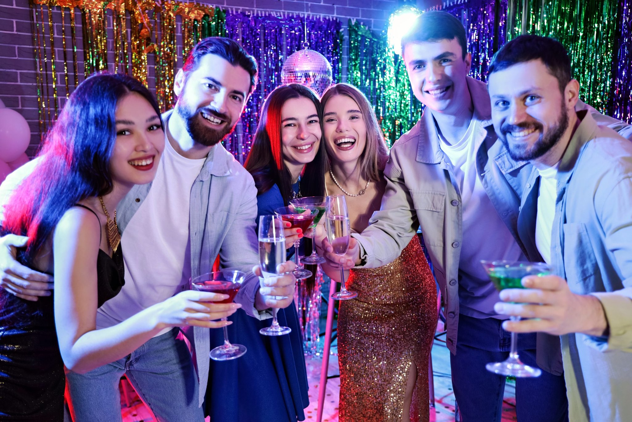 Six friends raise drinks together at a party