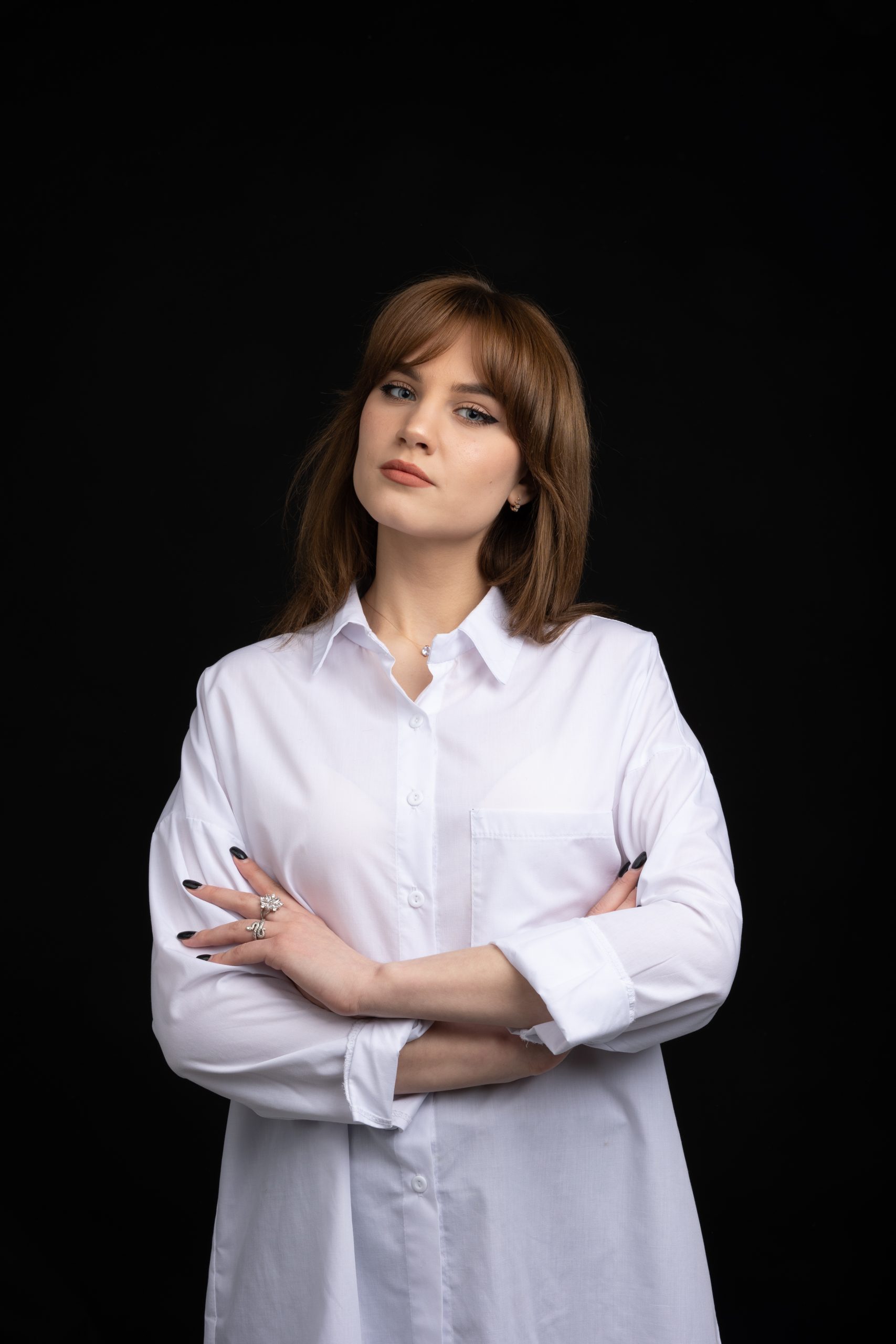 Woman in a white shirt standing with arms crossed
