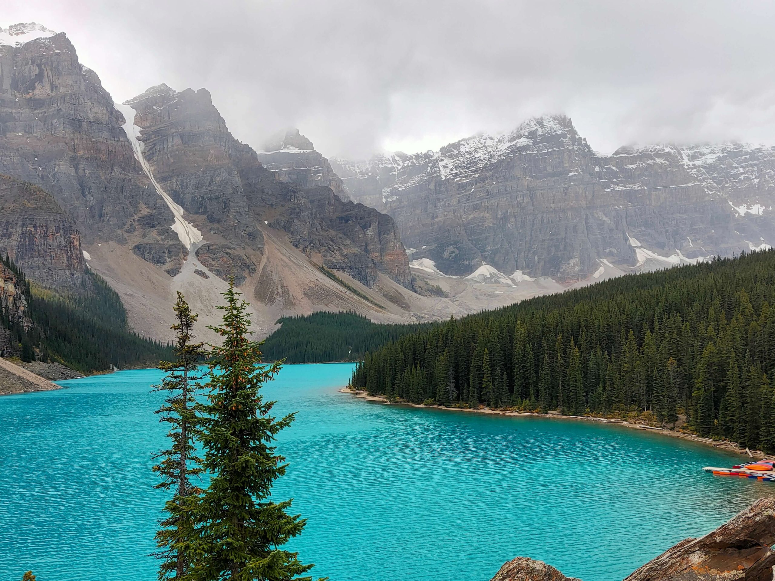 Turquoise mountain lake bordered by evergreen forest and snow-dusted peaks