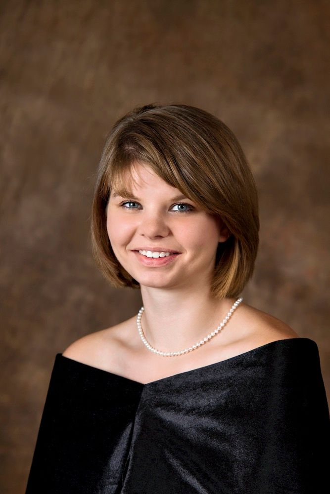 Young woman in formal drape and pearl necklace smiling