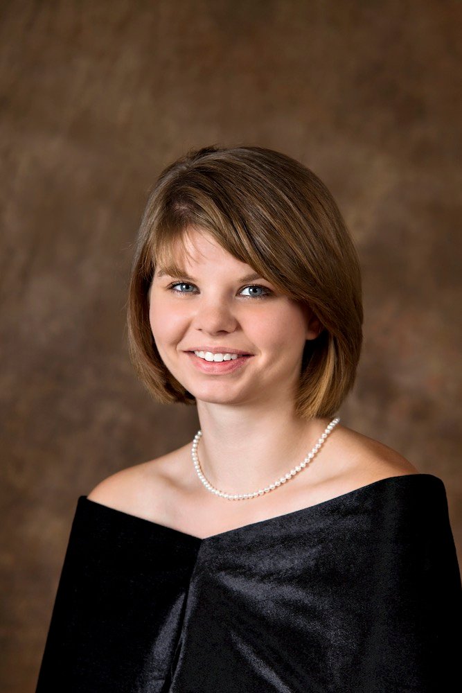 Young woman in formal drape and pearl necklace smiling