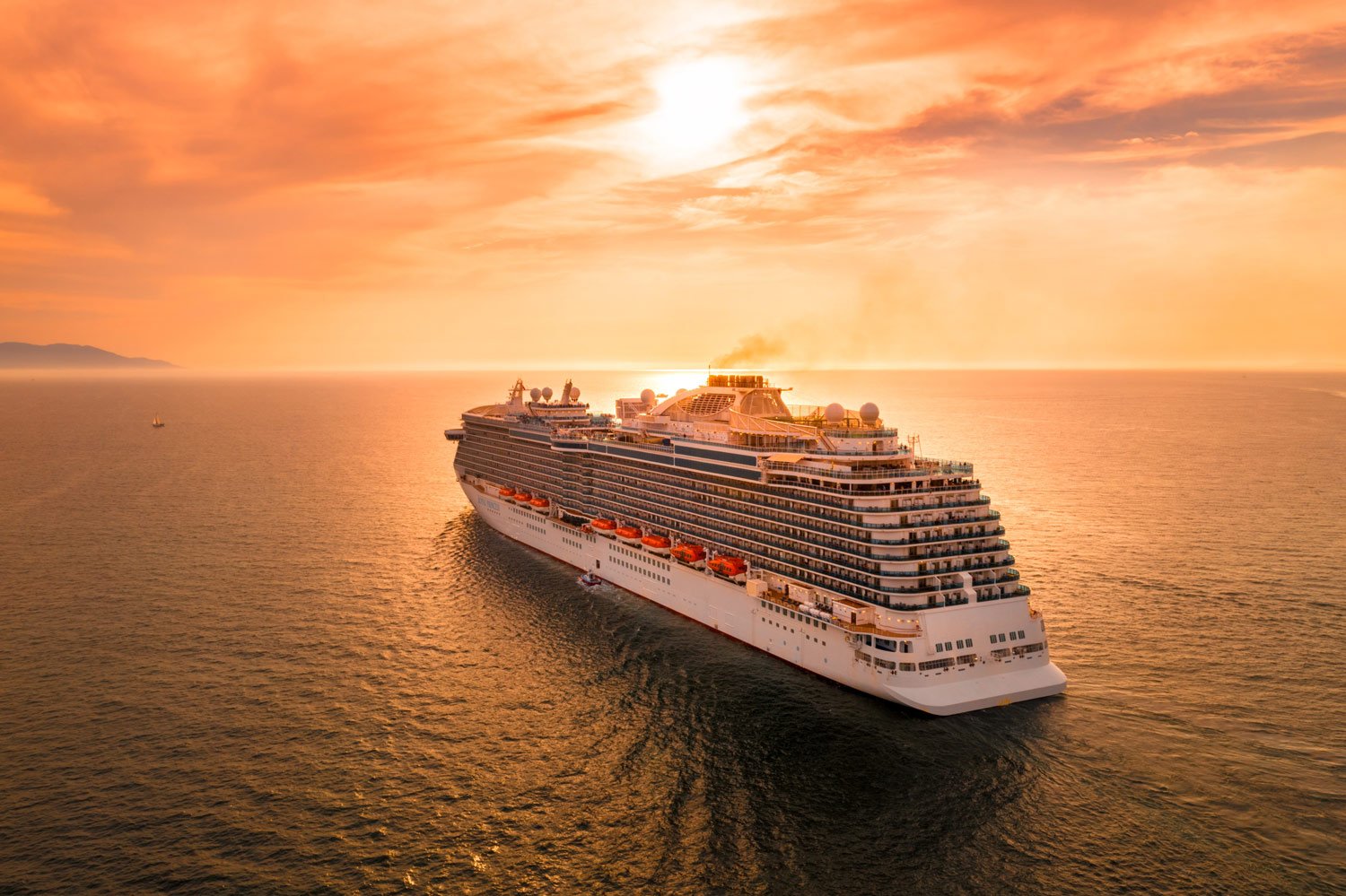 Cruise ship sailing on the open sea at sunset