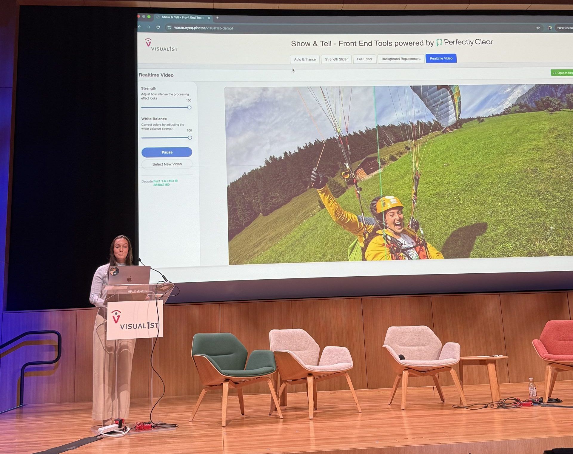 Presenter at a lectern demonstrating "Show & Tell - Front End Tools powered by Perfectly Clear" on stage
