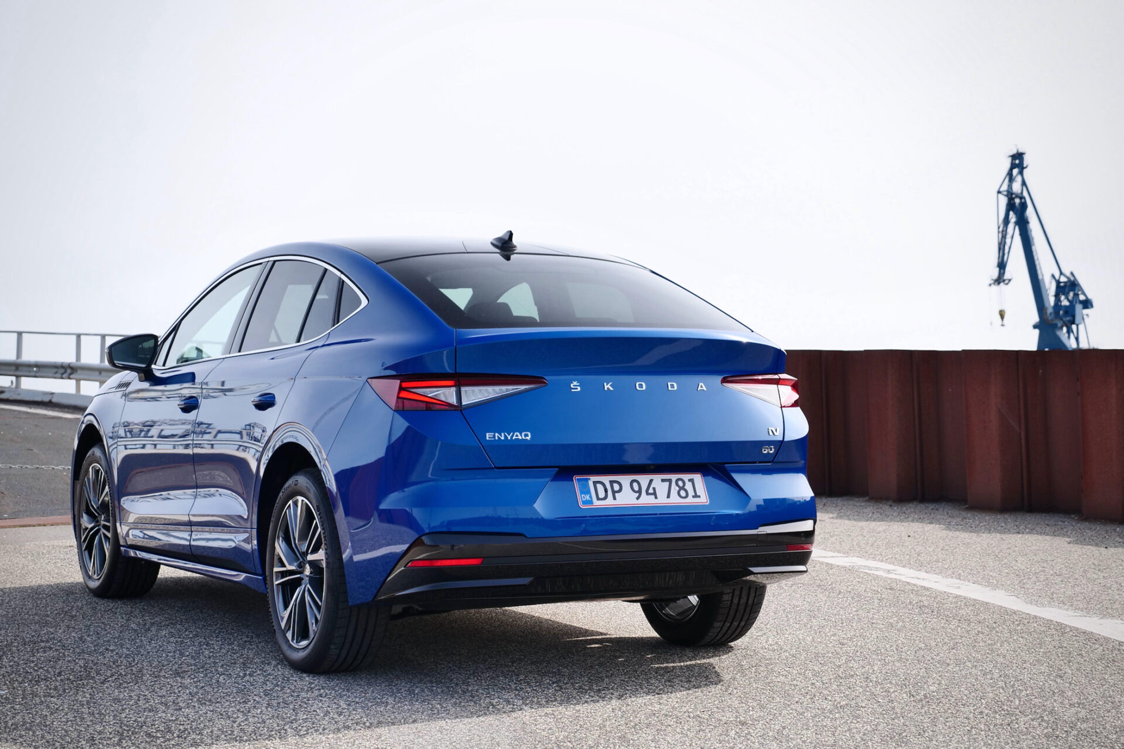 Blue Skoda Enyaq from behind at a harbour