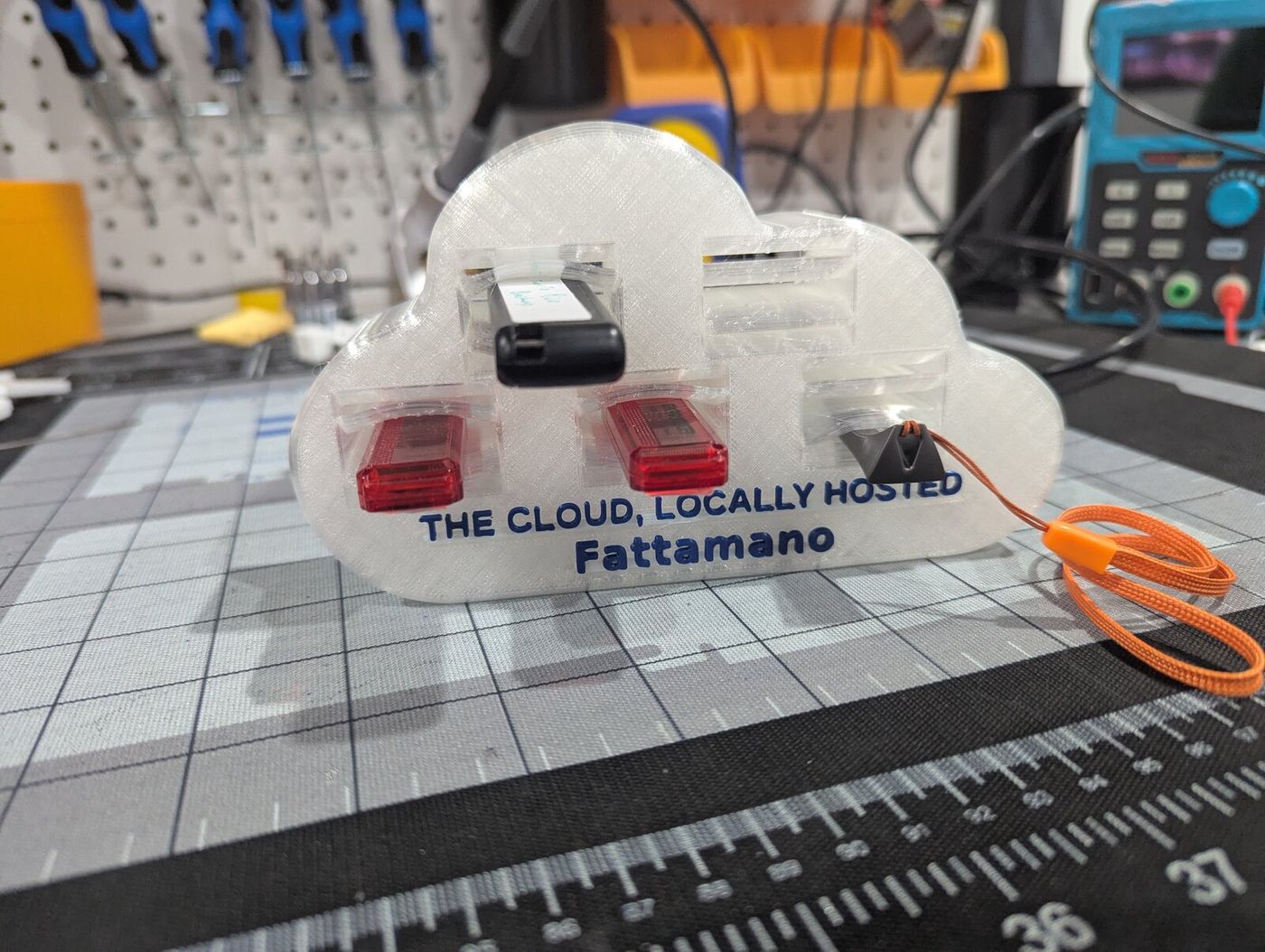 Translucent white 3D-printed cloud holding USB drives, with blue lettering reading THE CLOUD, LOCALLY HOSTED — Fattamano