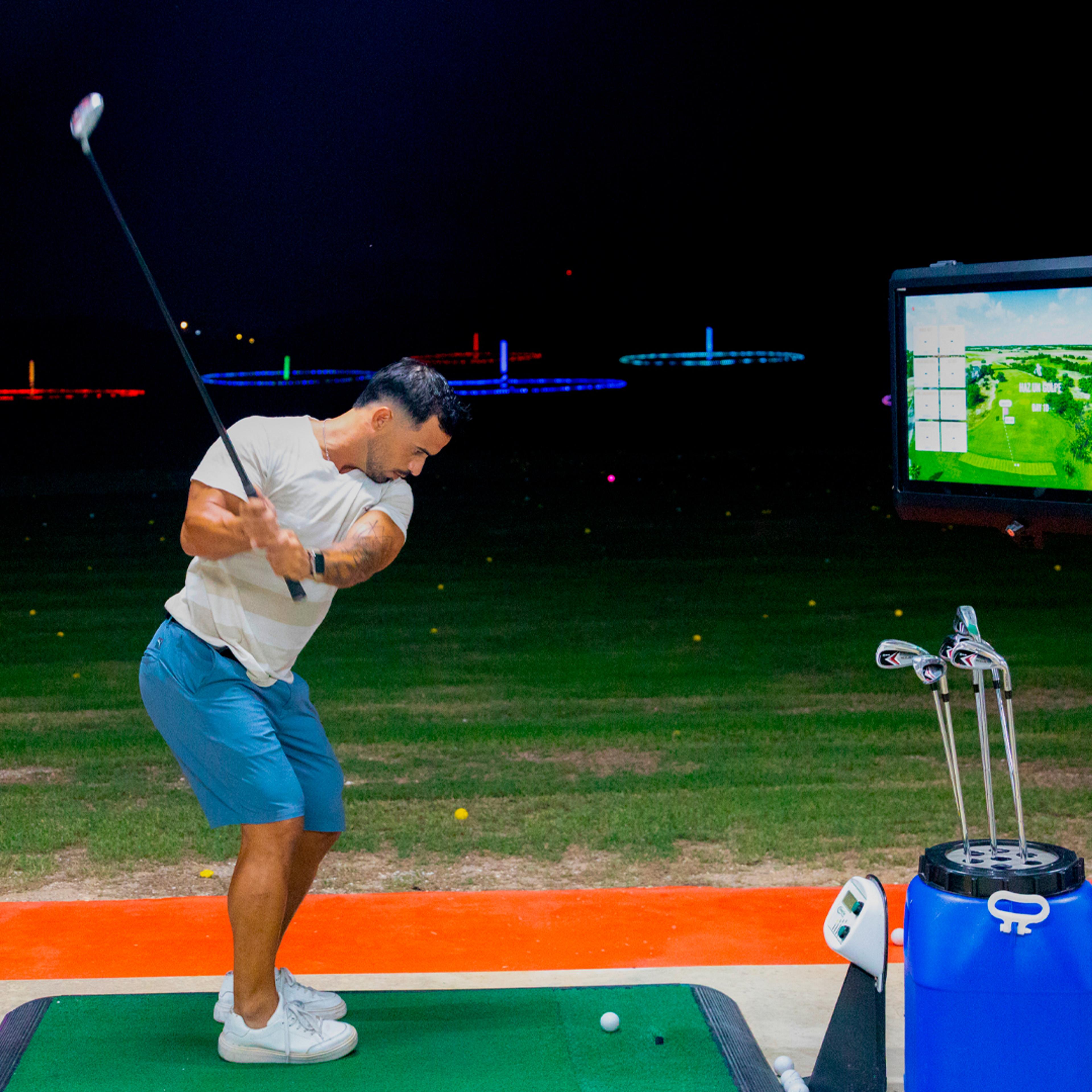 Golfer swinging at Golf N Shots Punta Cana under glow-in-the-dark targets