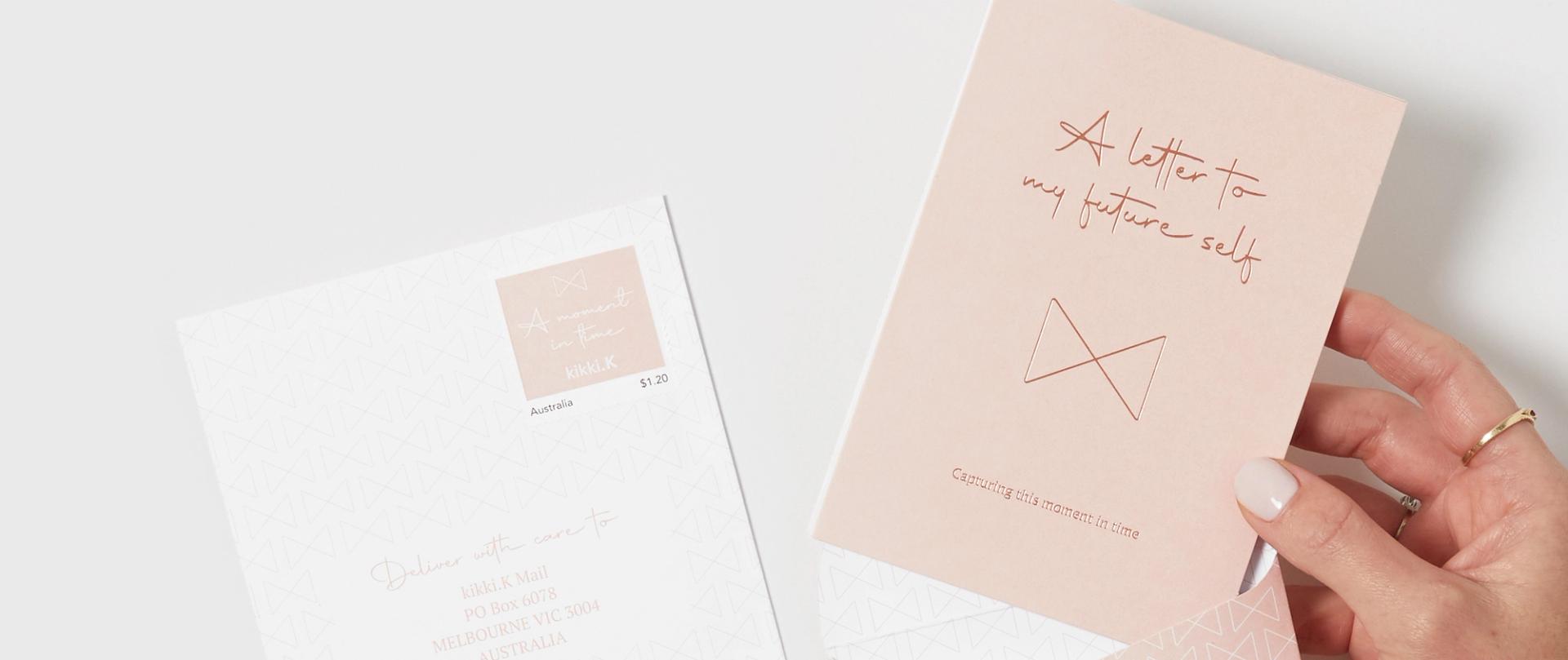 a person opening a pink envelope