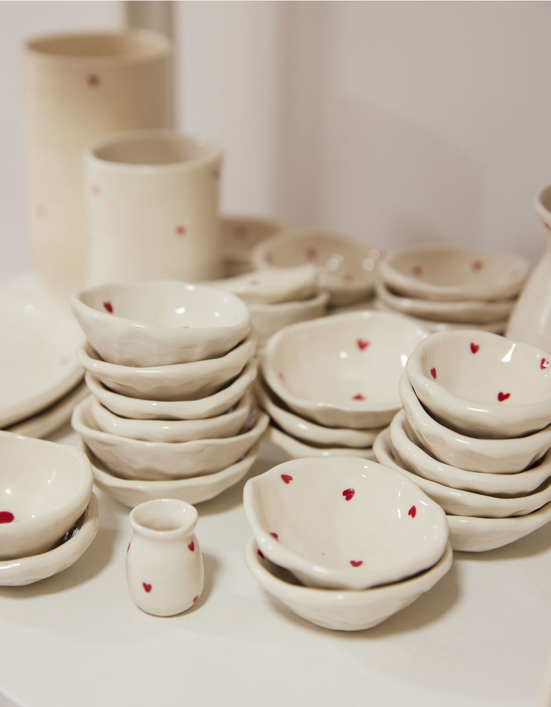 A group of handmade ceramic bowls with painted love hearts