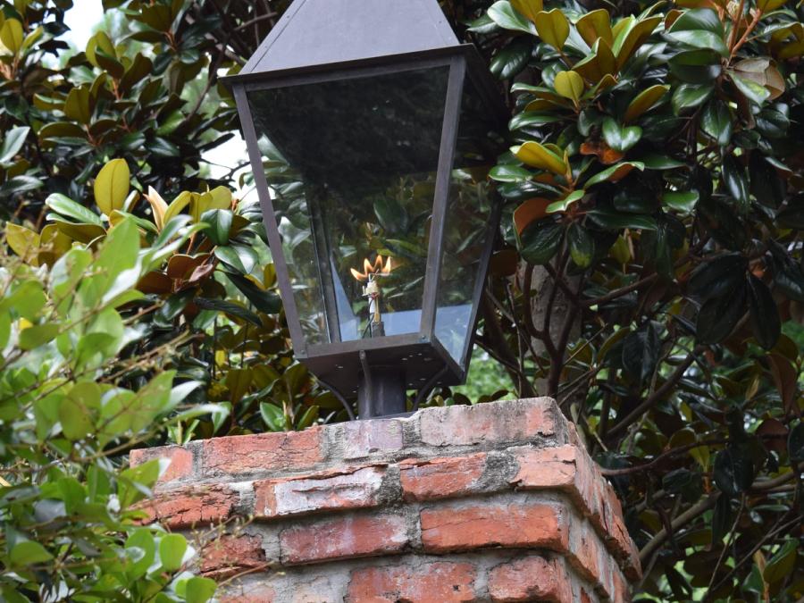 Gas lantern bolted flat onto the top of a brick pier