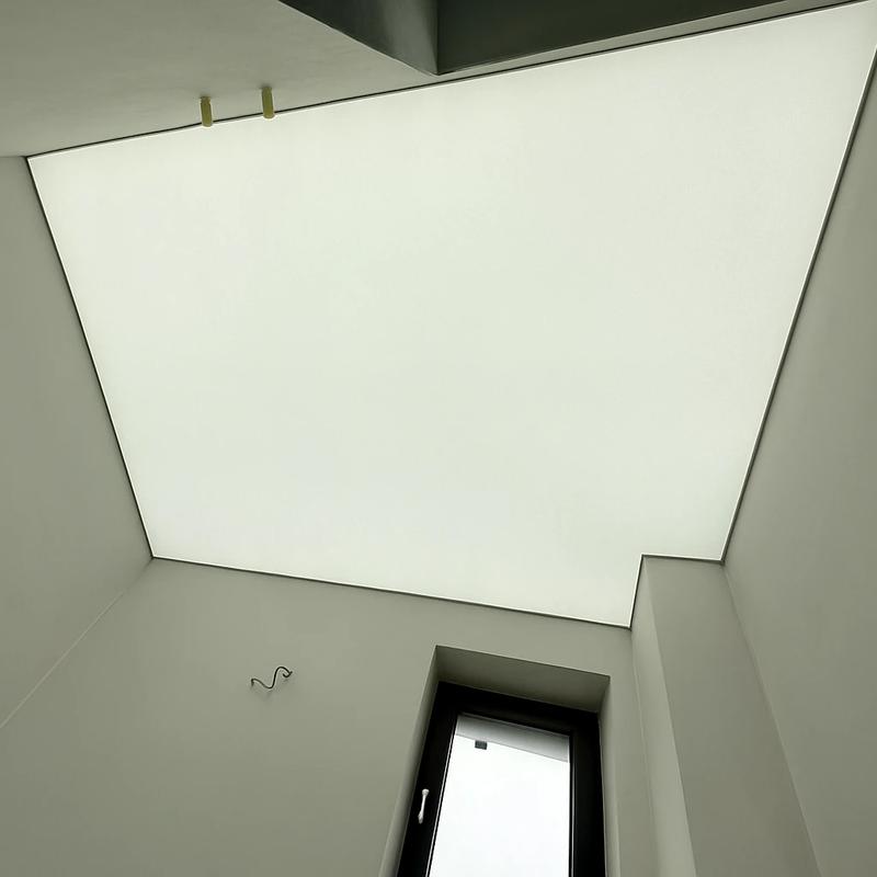 Tavan extensibil translucid într-o baie modernă, iluminare difuză și design minimalist.