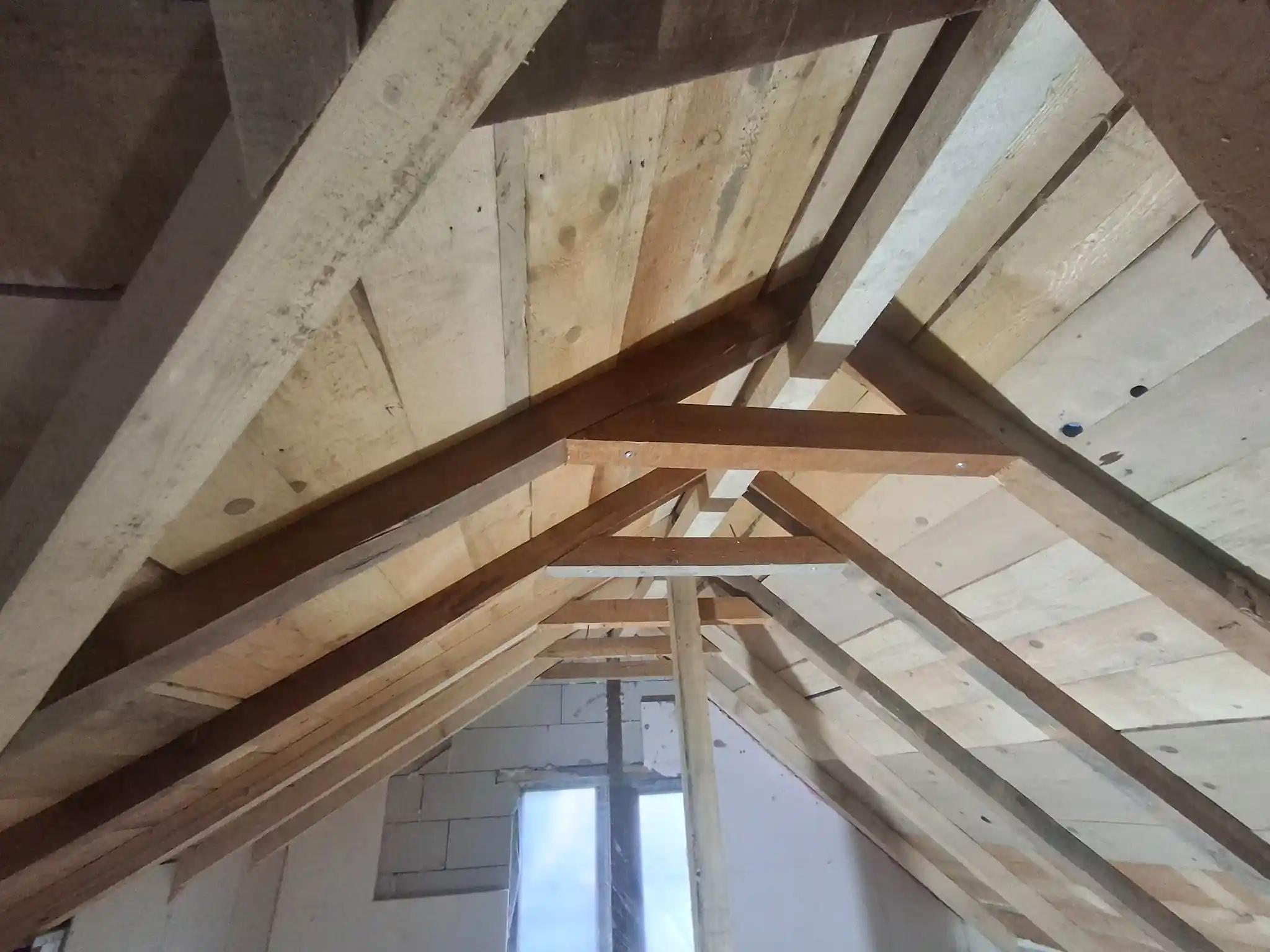 Structură de acoperiș din lemn neizolată, vedere din pod înainte de aplicarea spumei