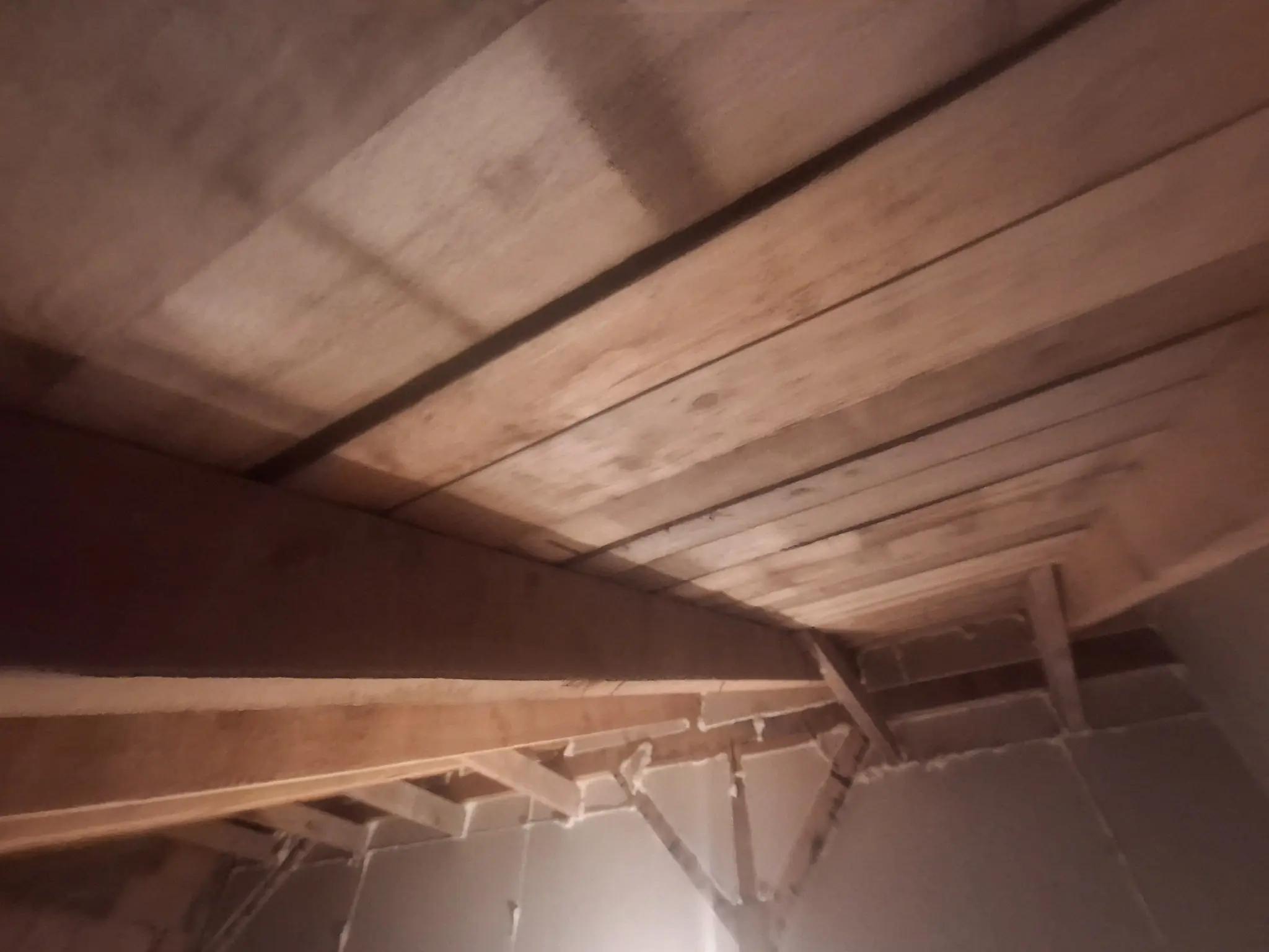 Colț de pod cu elemente structurale unde se aplică izolație cu spumă poliuretanică