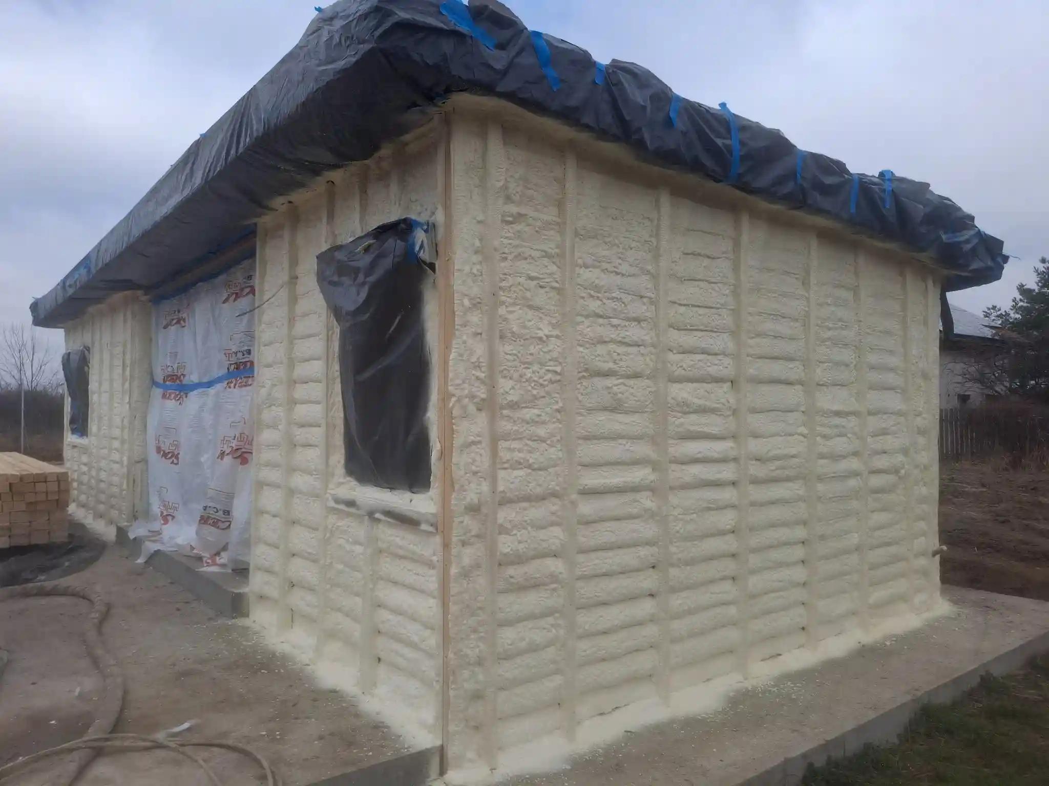 Colț casă din lemn dupa aplicarea spumei poliuretanice, montaj structură pentru izolație exterioară