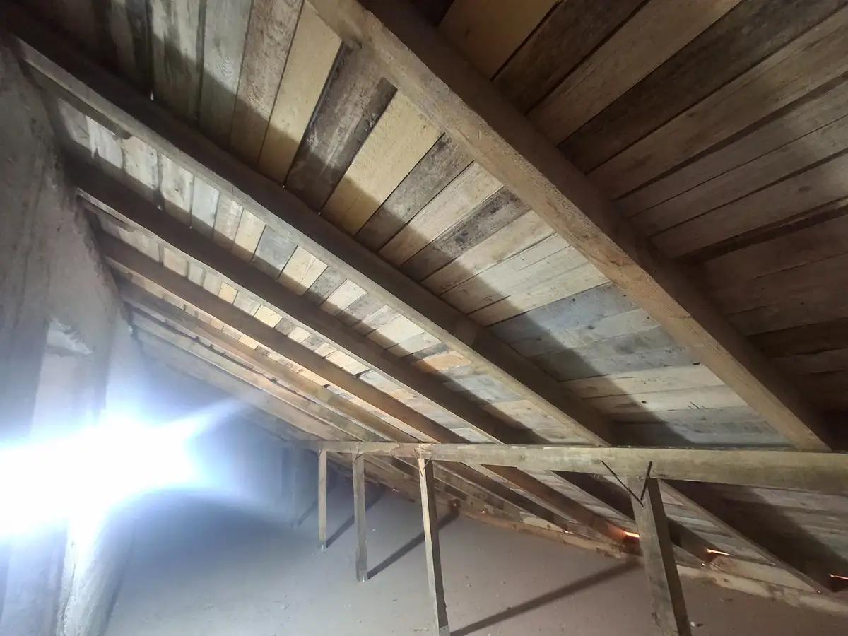 Vedere de jos în sus a asterealei și grinzilor din lemn ale podului, înainte de aplicarea spumei poliuretanice cu celulă deschisă – Horezu, Vâlcea