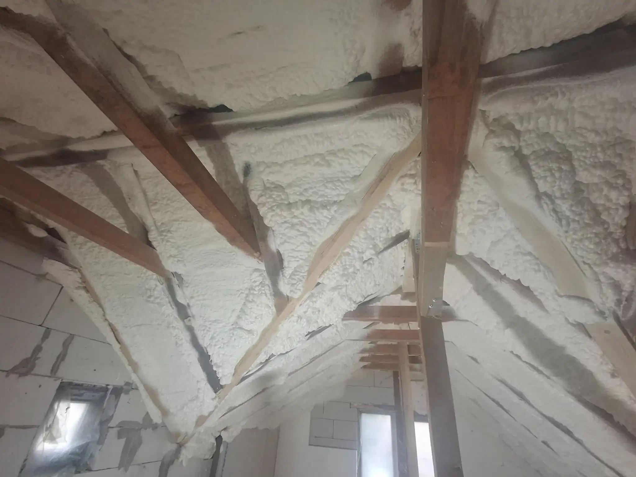 Pod izolat cu spumă poliuretanică aplicată pe astereală și grinzi din lemn