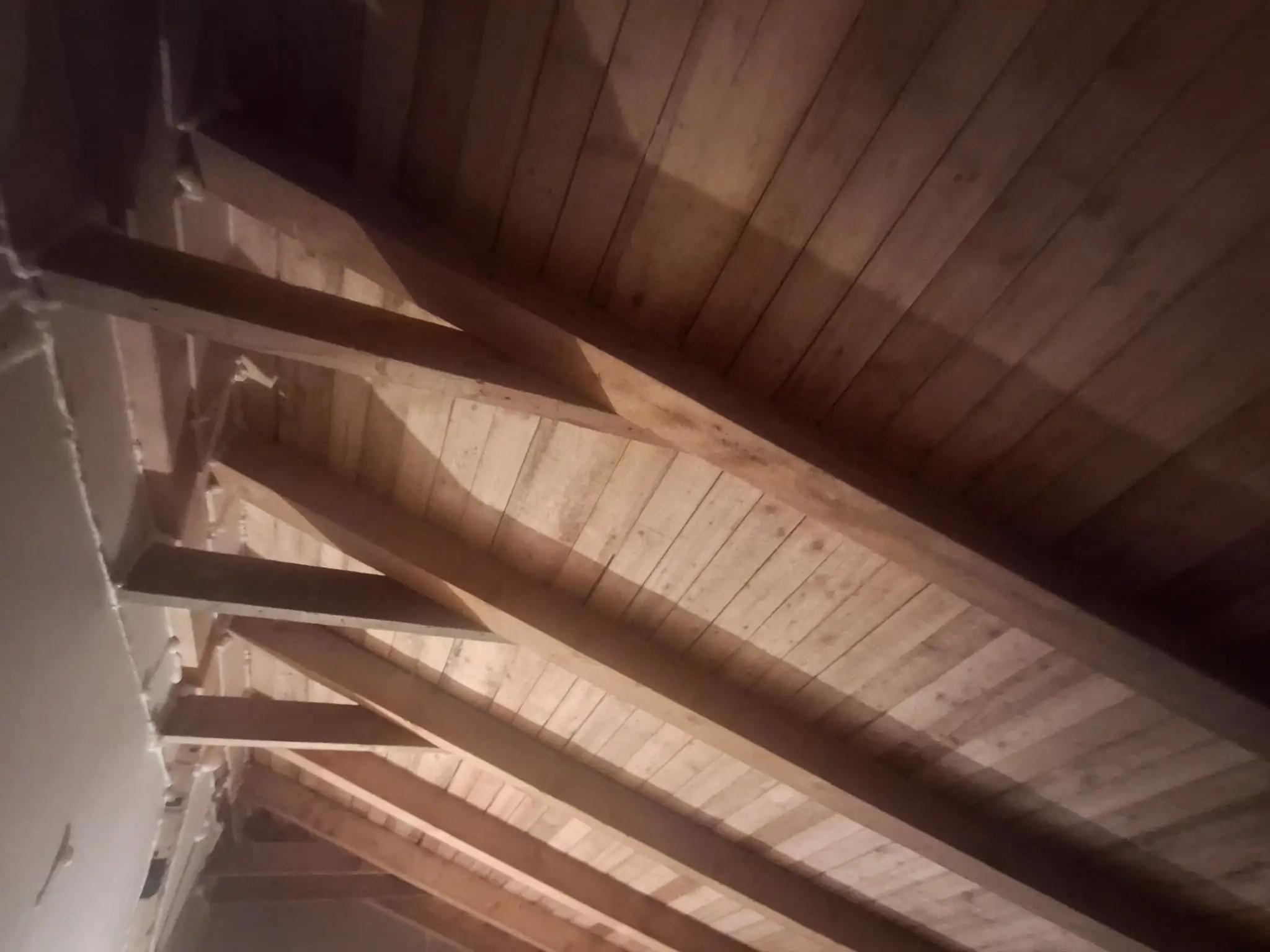 Căpriori din lemn și astereală într-un pod înainte de izolare termică