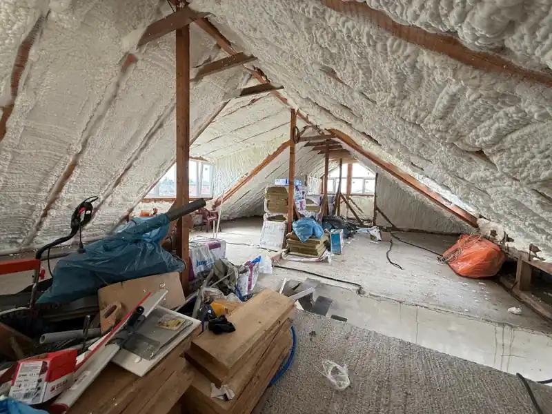 Mansardă izolată cu spumă poliuretanică aplicată pe toată suprafața acoperișului, structură din lemn vizibilă, spațiu pregătit pentru amenajare.