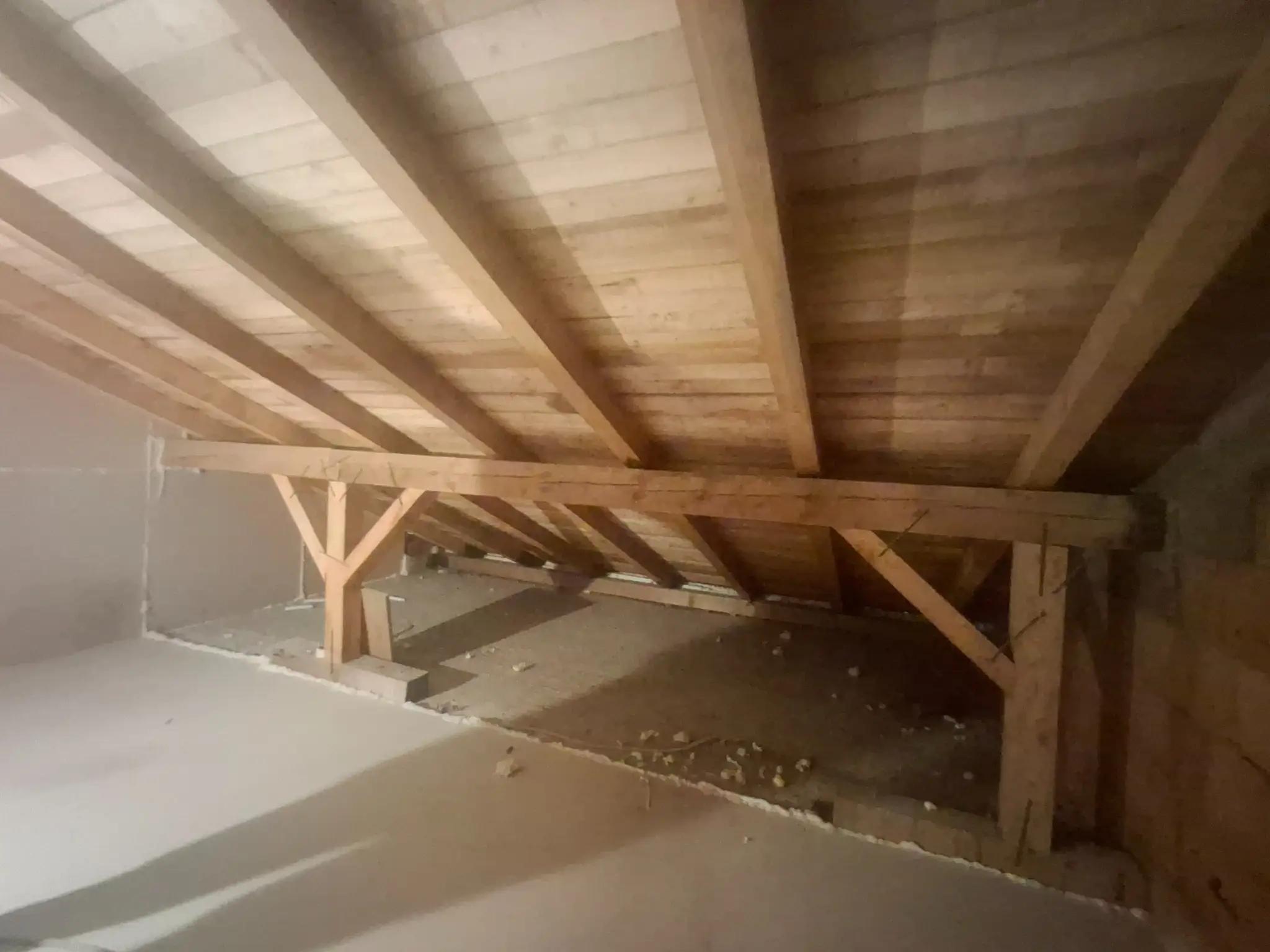 neizolat cu grinzi din lemn și astereală vizibilă înainte de aplicarea spumei poliuretanice