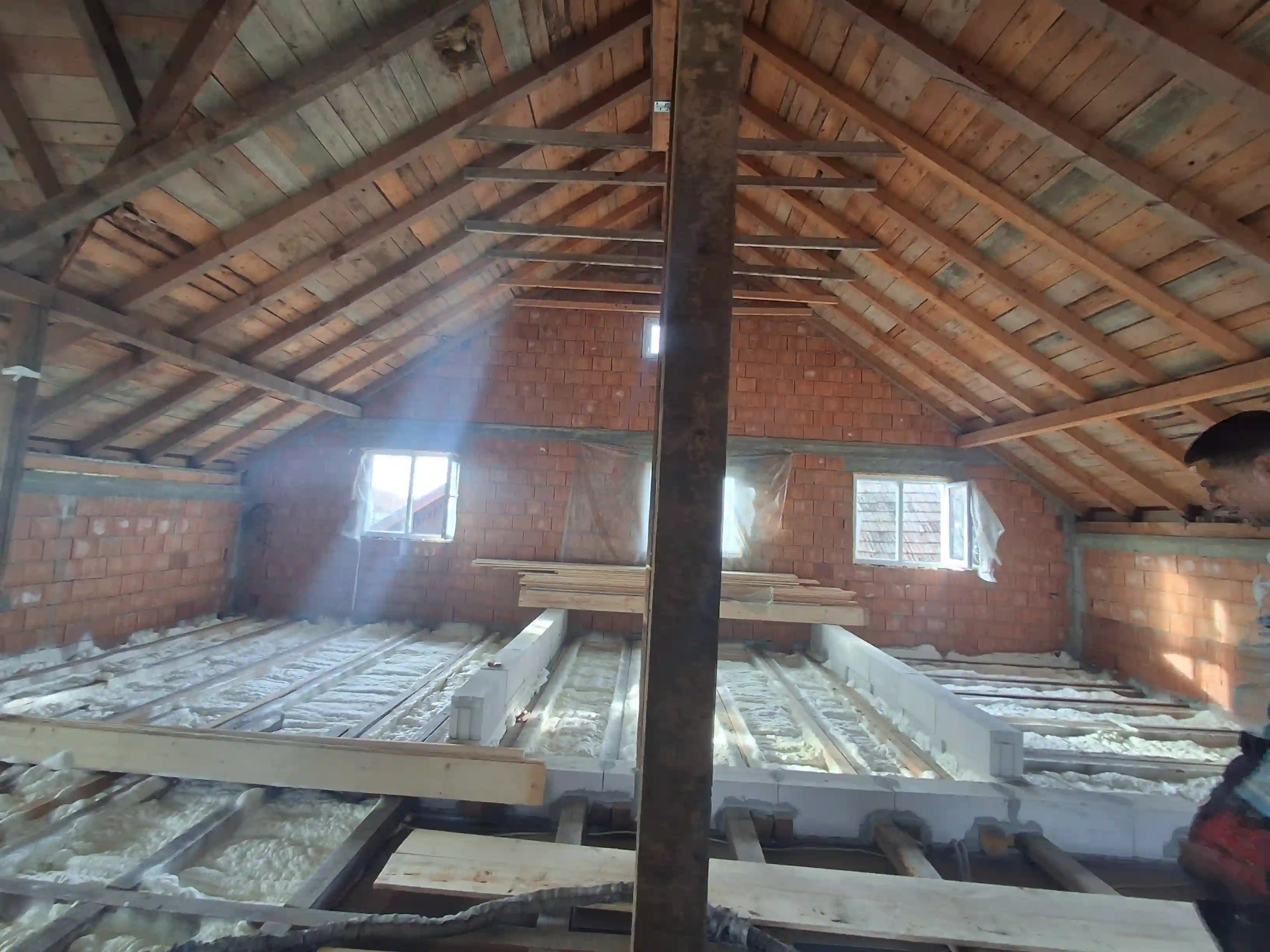 Izolație mansardă realizată în Sânnicolau Mare cu spumă poliuretanică cu celulă deschisă aplicată pe planșeu, grosime 12 cm.