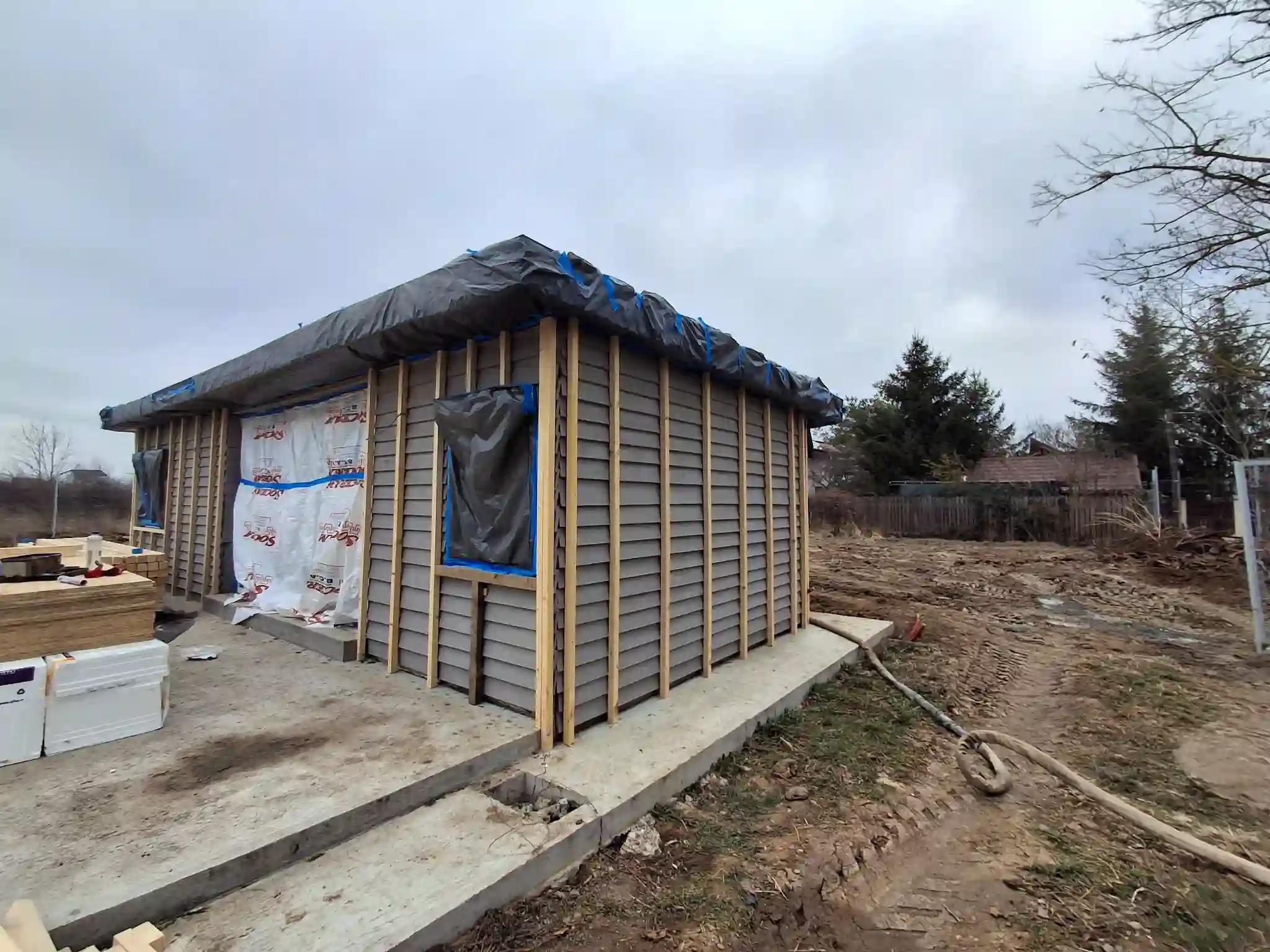 Colț casă din lemn înainte de aplicarea spumei poliuretanice, montaj structură pentru izolație exterioară