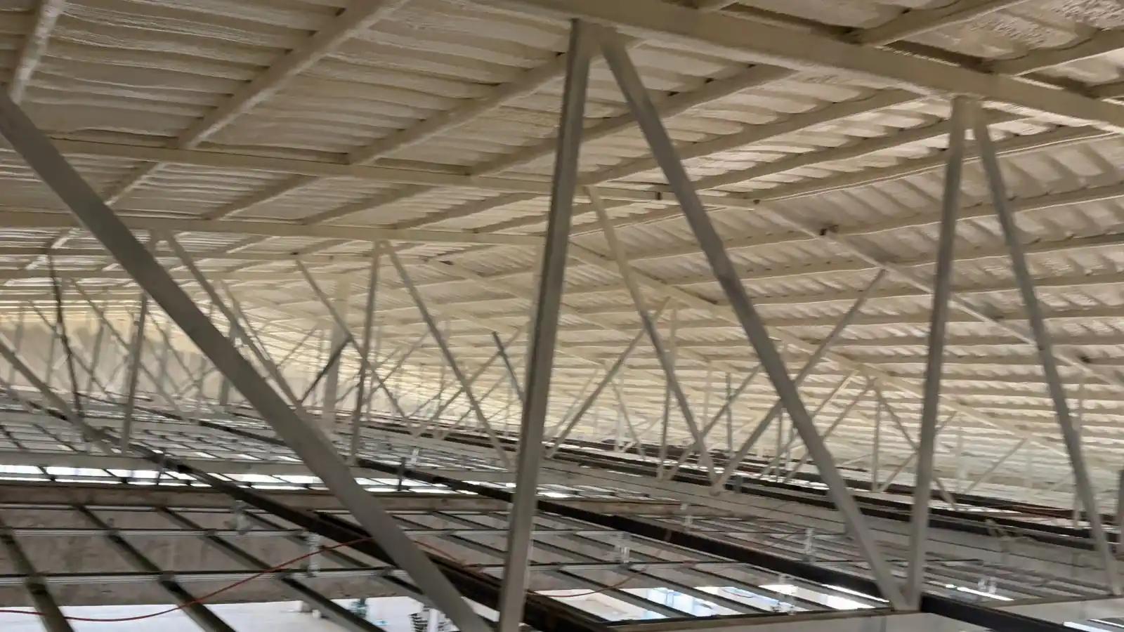 Detaliu aplicare spumă poliuretanică celulă închisă 5 cm pe structura metalică a halei