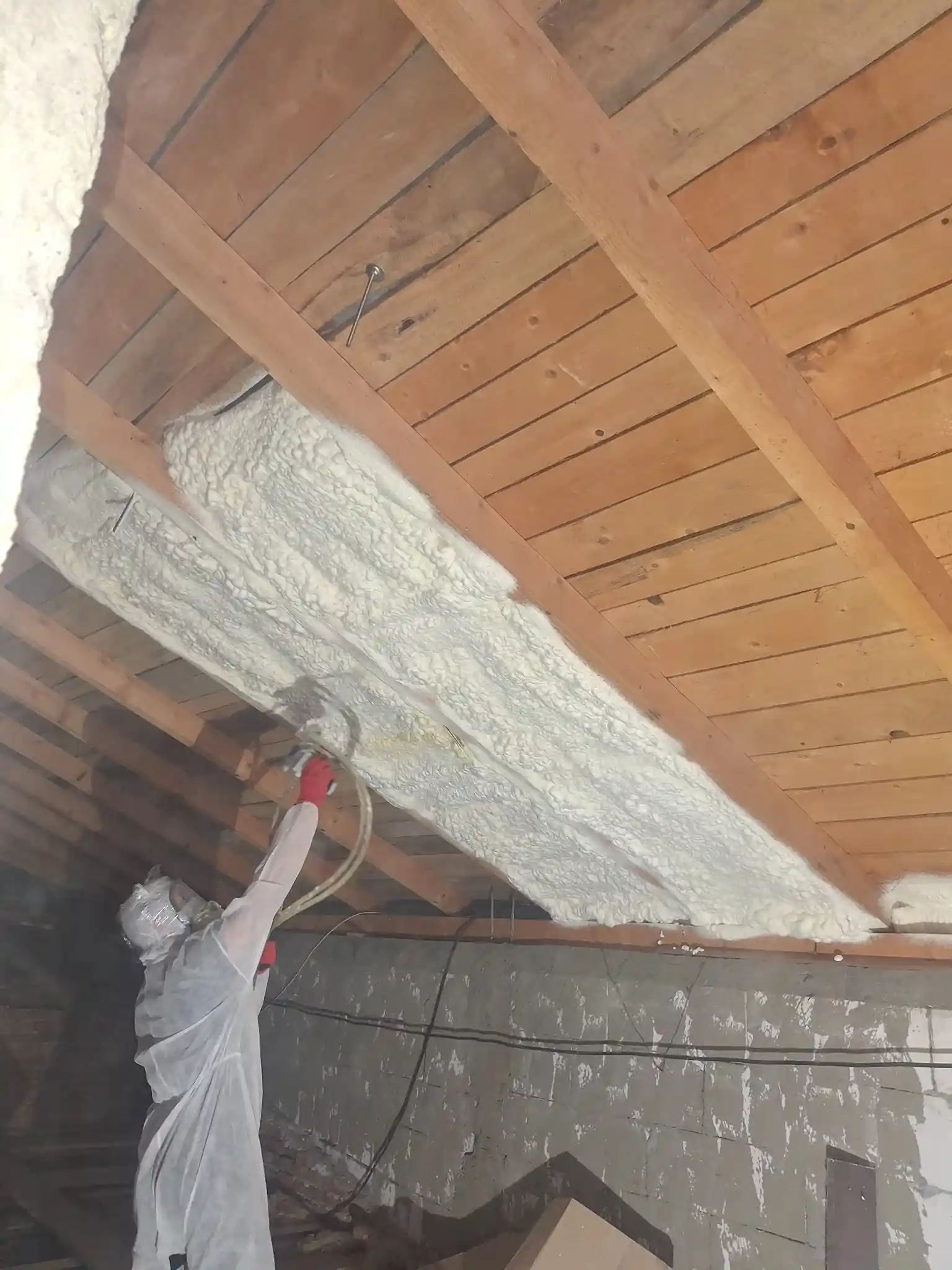 Aplicare spumă poliuretanică cu celulă deschisă pe acoperiș din lemn, izolație termică profesională realizată de Termoizolații România în Dolj